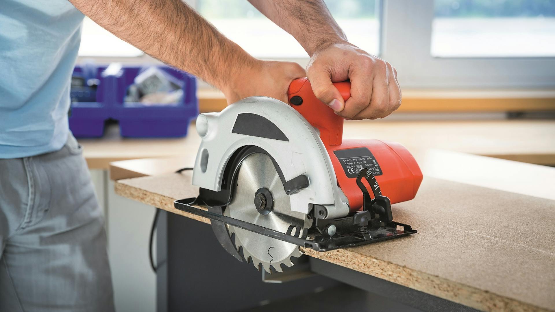 Handwerker sägt mit einer Handkreissäge eine Platte zu.