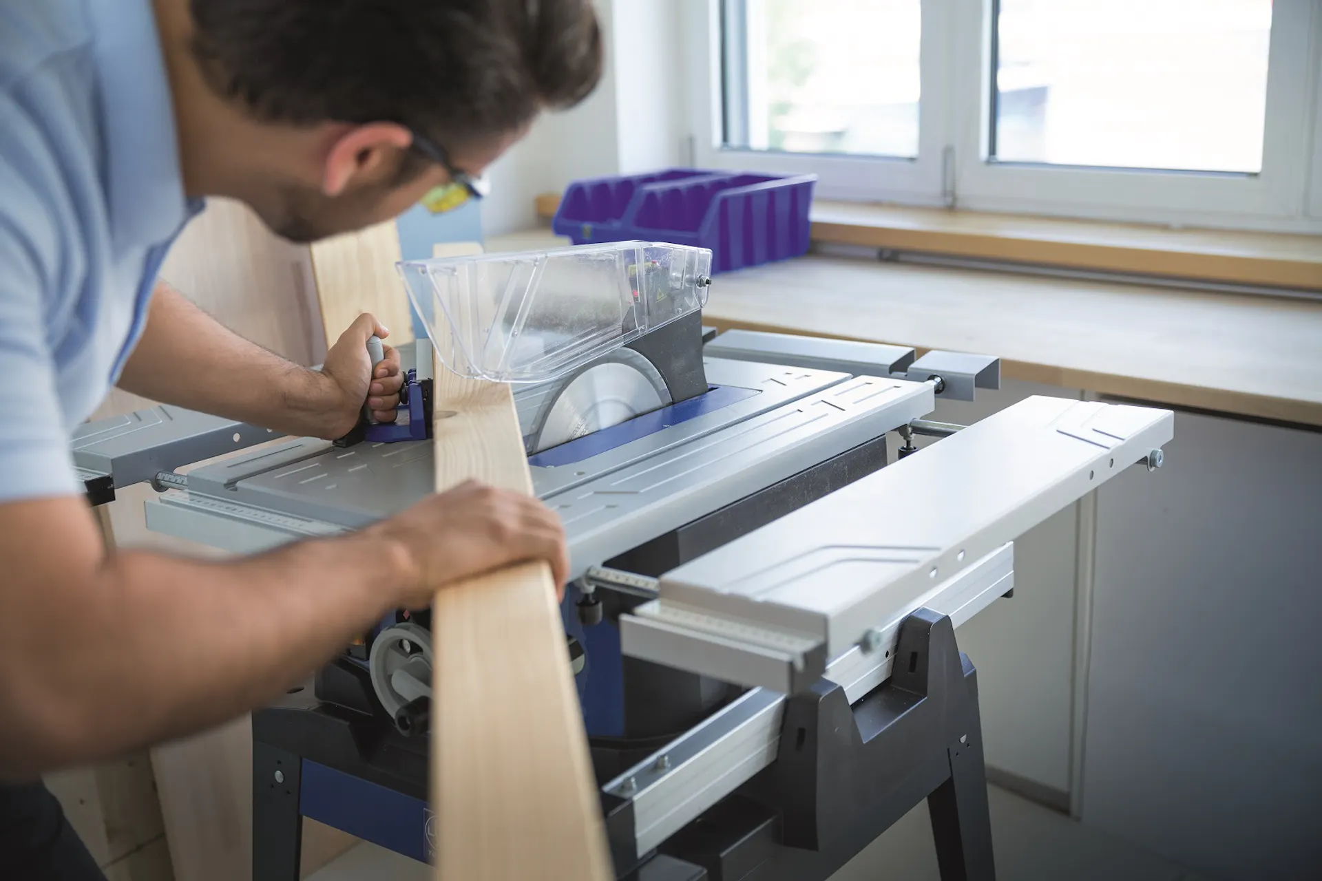 Un bricoleur utilise une scie circulaire pour découper un morceau de bois.
