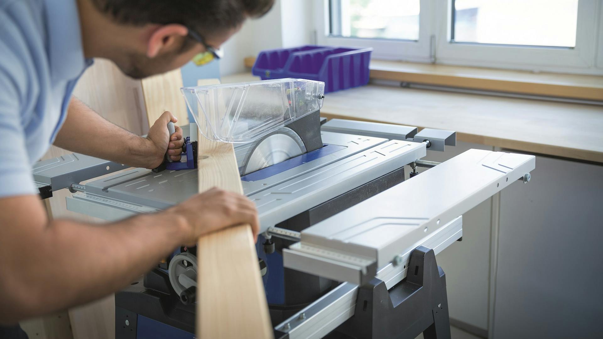 Handwerker sägt mit einer Kreissäge ein Stück Holz zu.