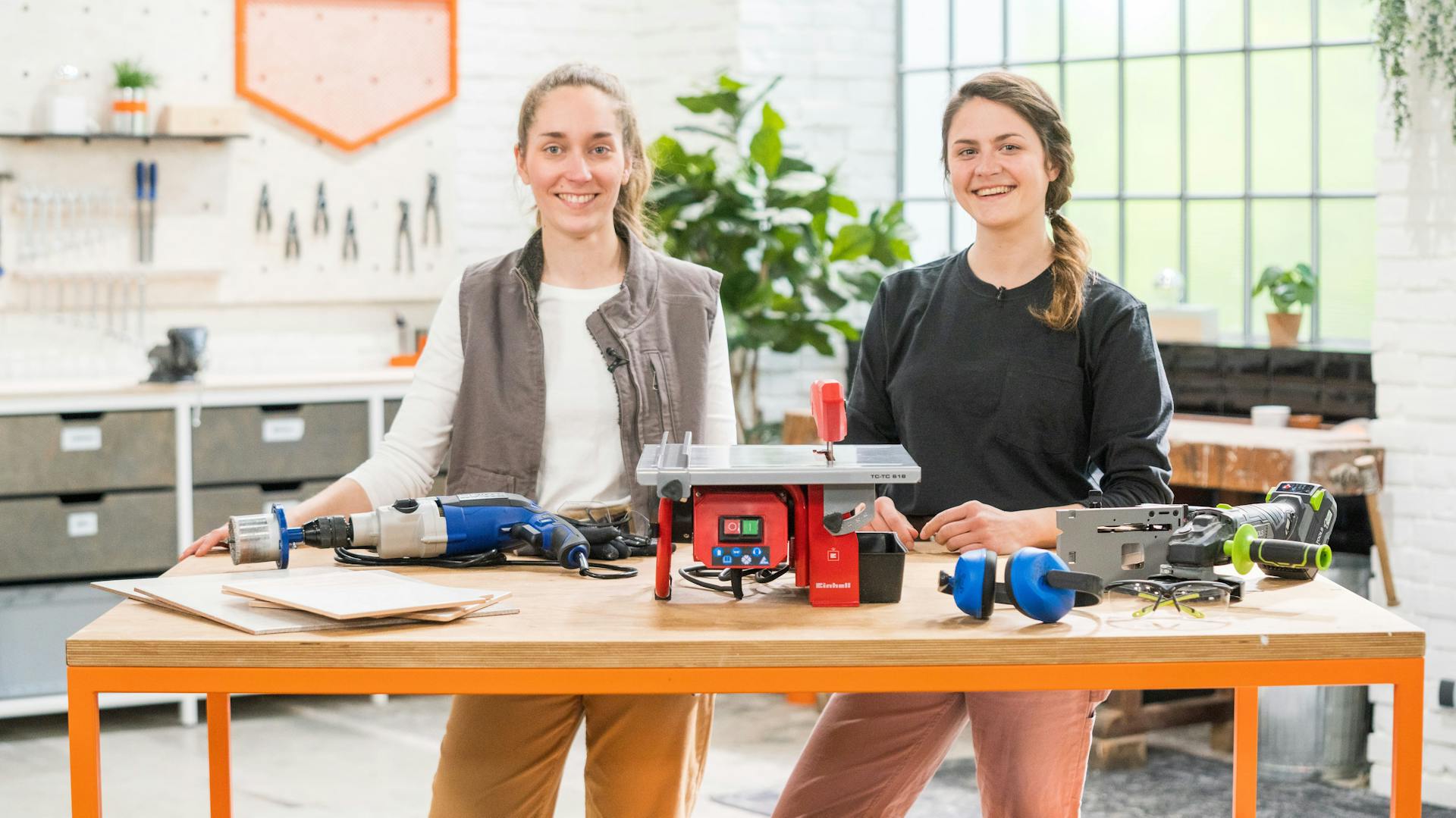 Zwei Frauen hinter einem Tisch mit Werkzeug zum Brechen von Fliesen