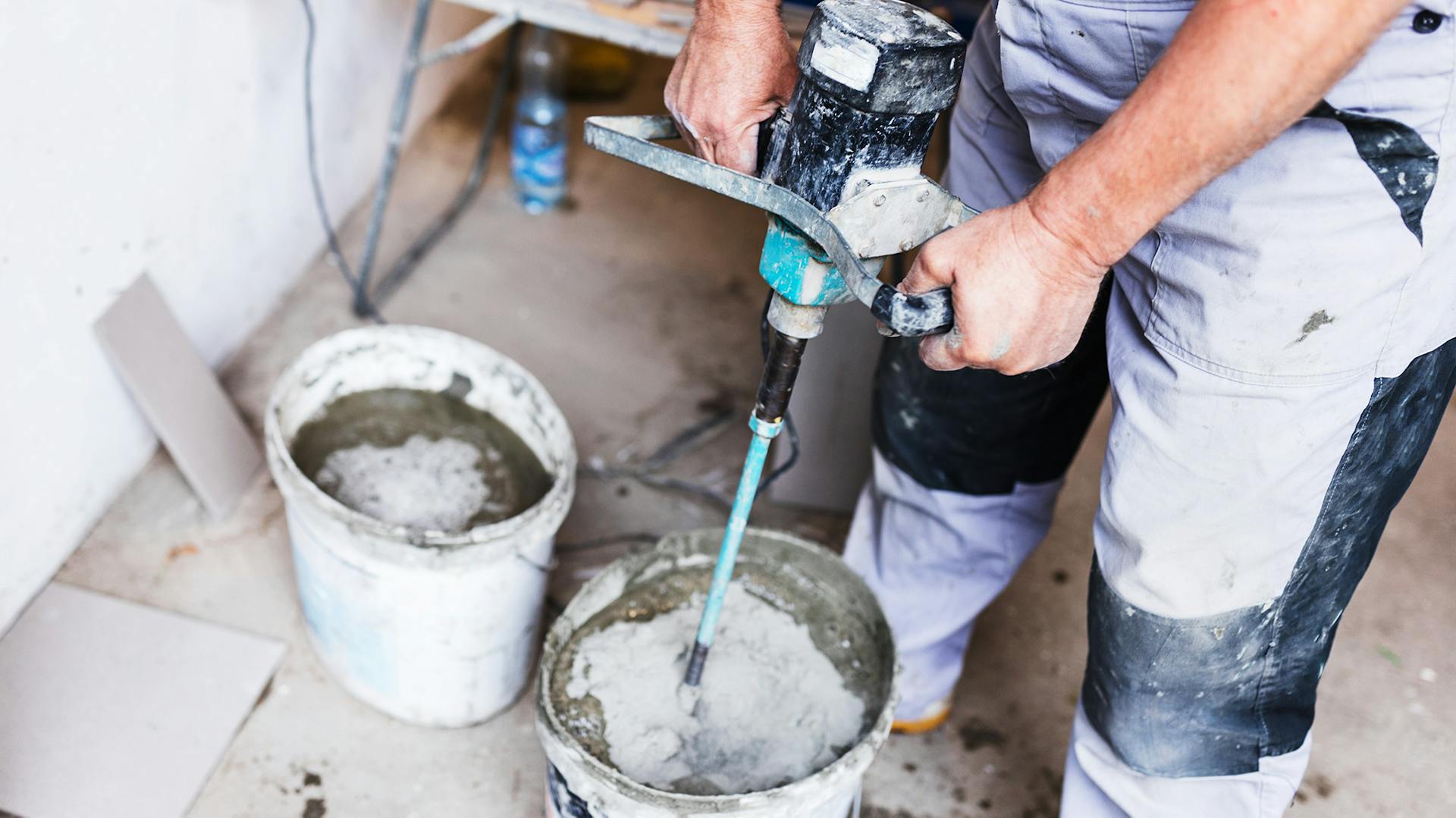 Mörtelrührer wird im Mischgefäß bedient.