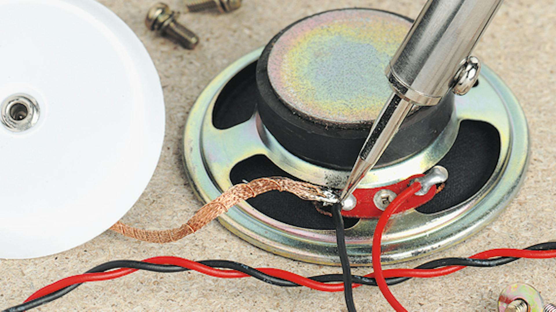 Eine Lautsprecherkabelverbindung wird mit einem Lötkolben entlötet.