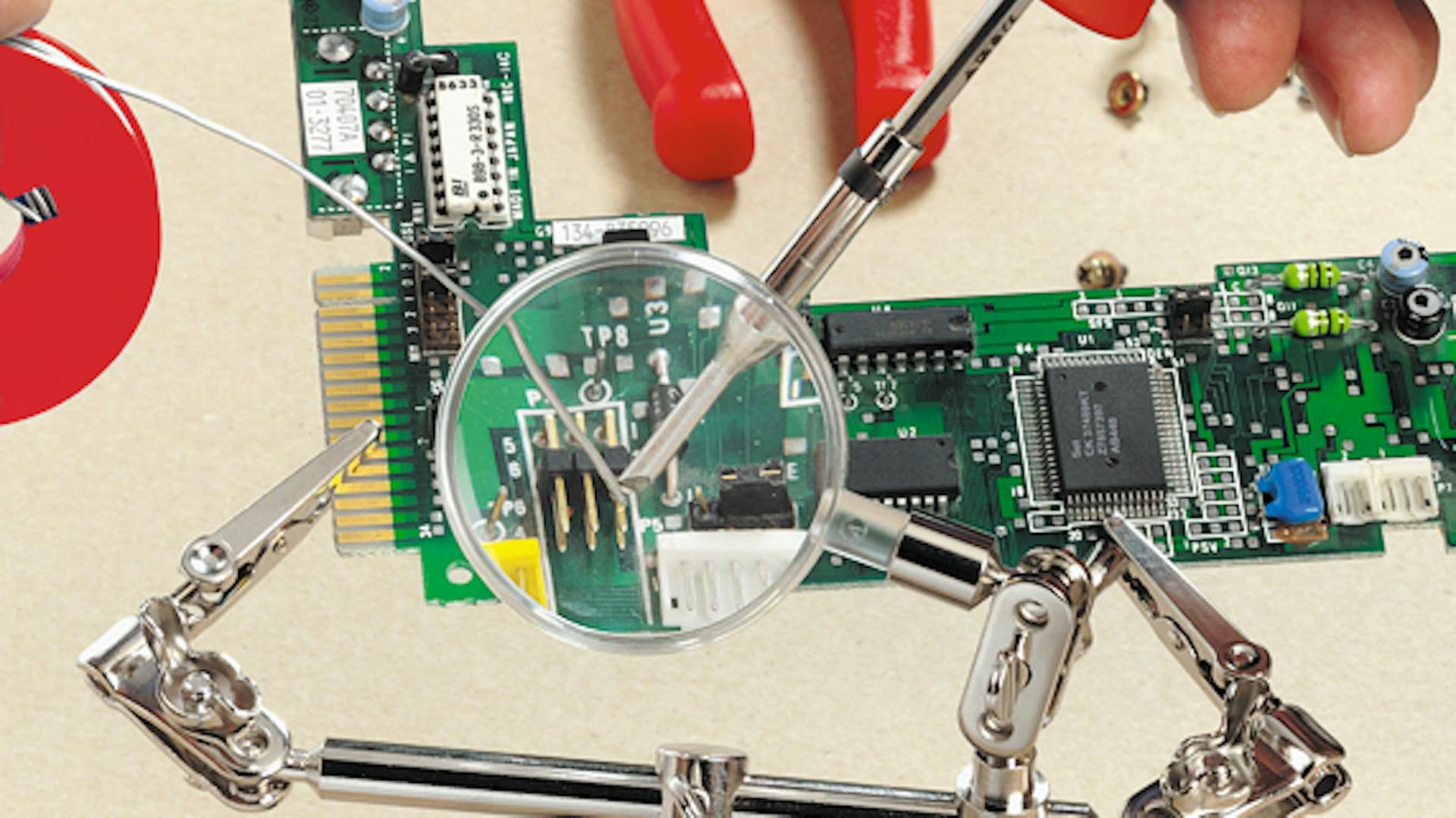 Leiterplatte wird unter der Lupe gelötet.