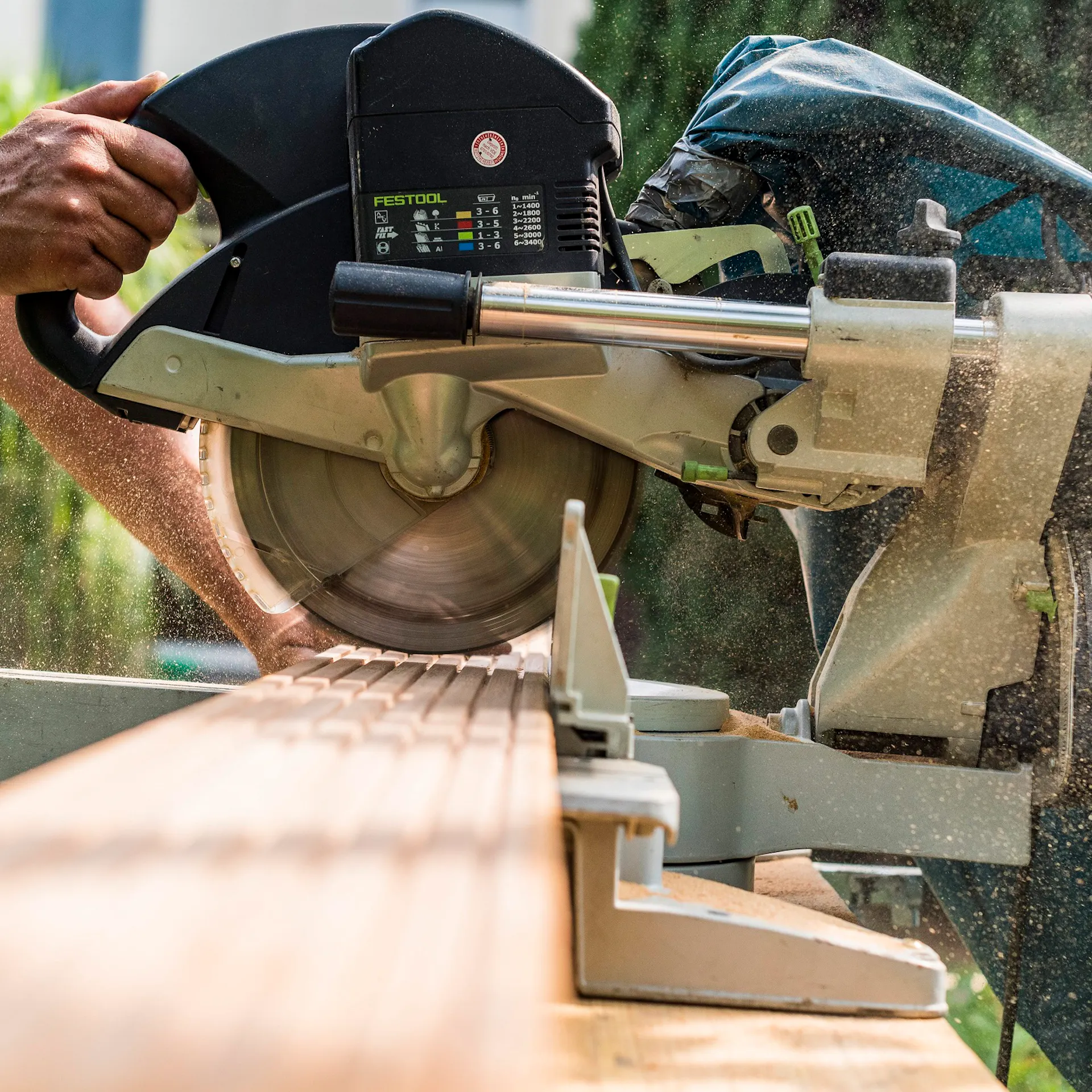 Egy barkácsoló deszkát vág méretre körfűrésszel.