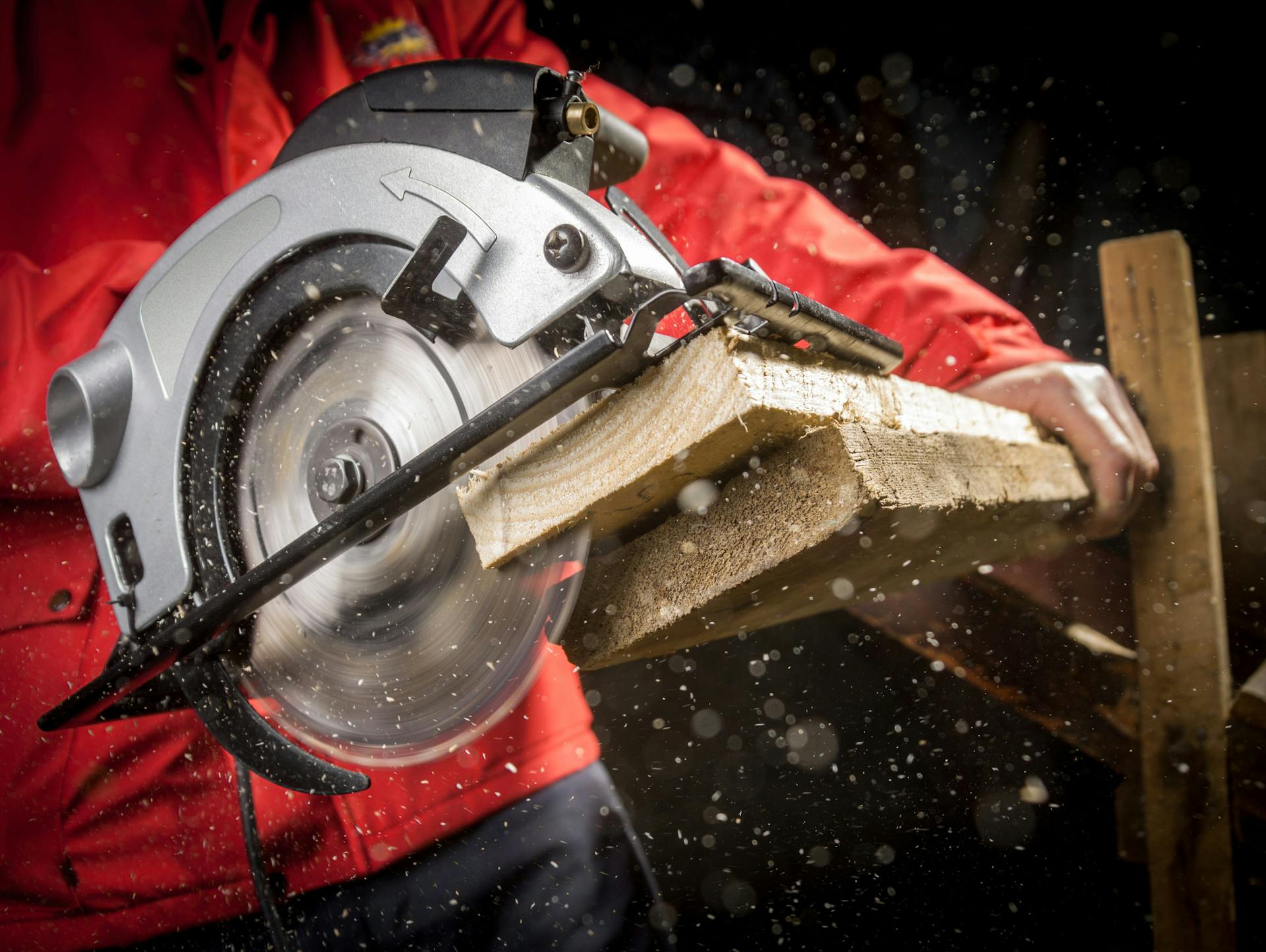 Egy ember fadeszkát vág egy körfűrésszel.