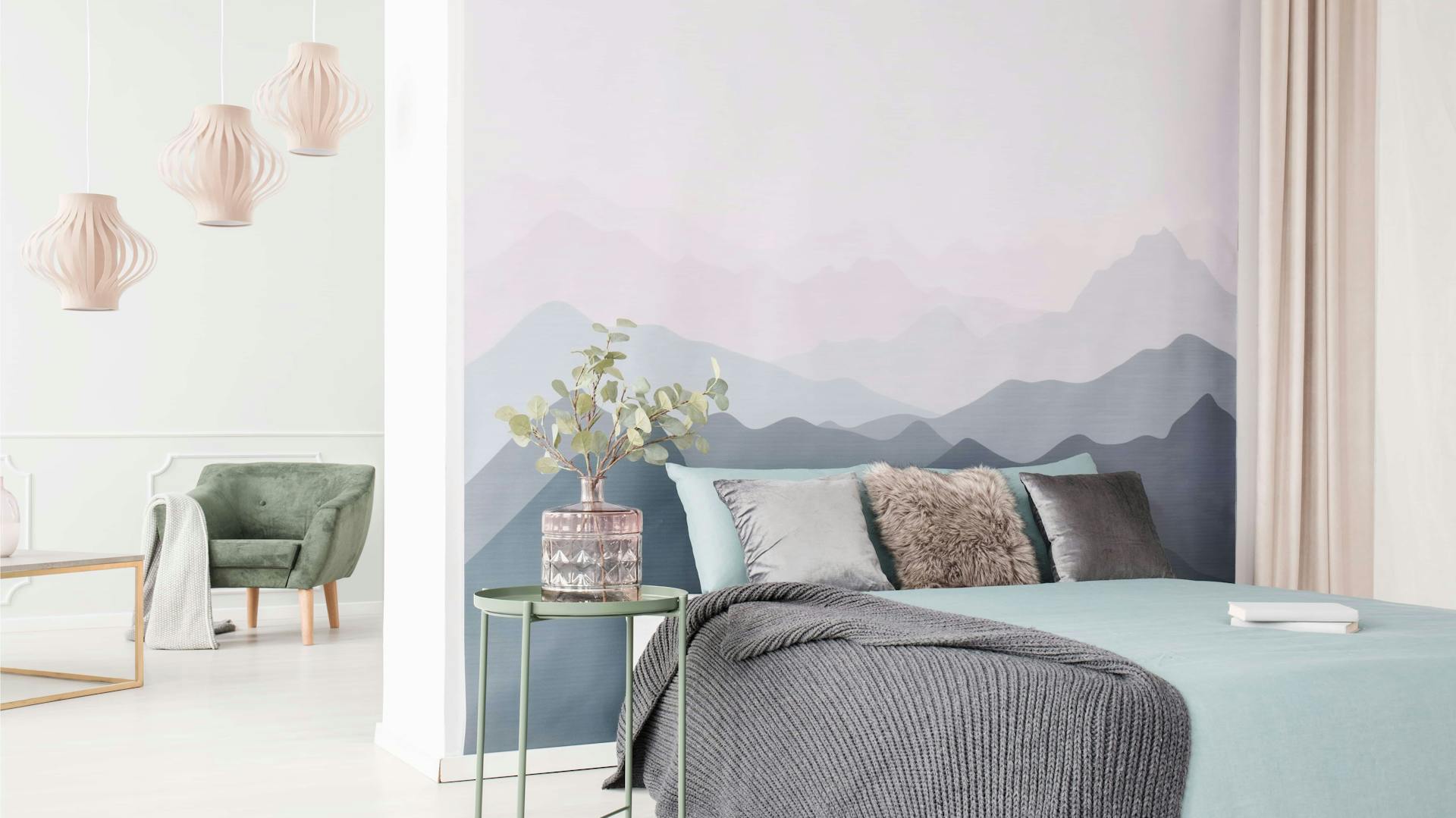 Ein Bett vor einer Tapete mit Bergmotiv.