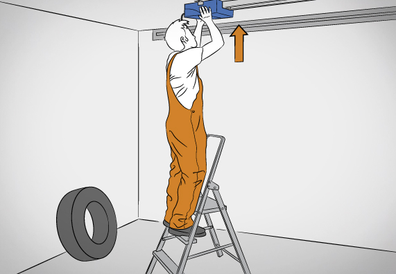 Mann fixiert und richtet Garagentormotor aus.