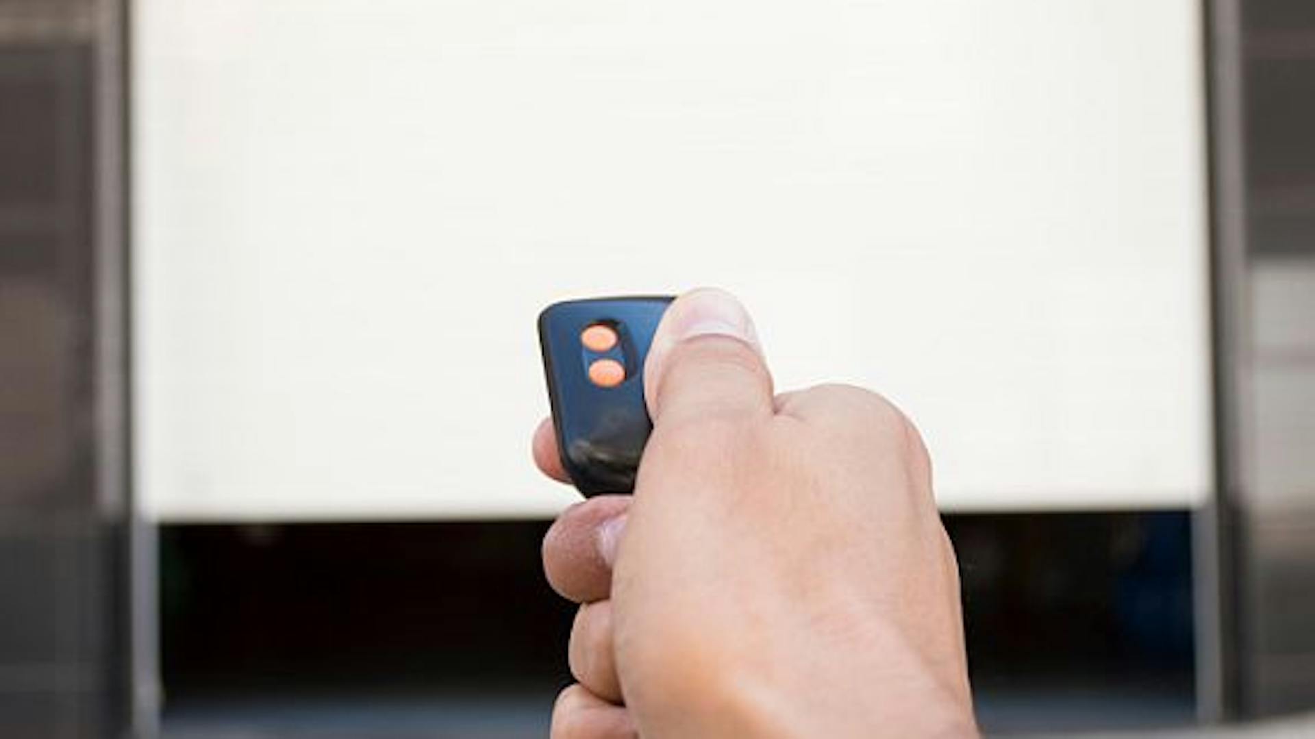 Ferngesteuerter Garagenöffner öffnet ein Garagentor