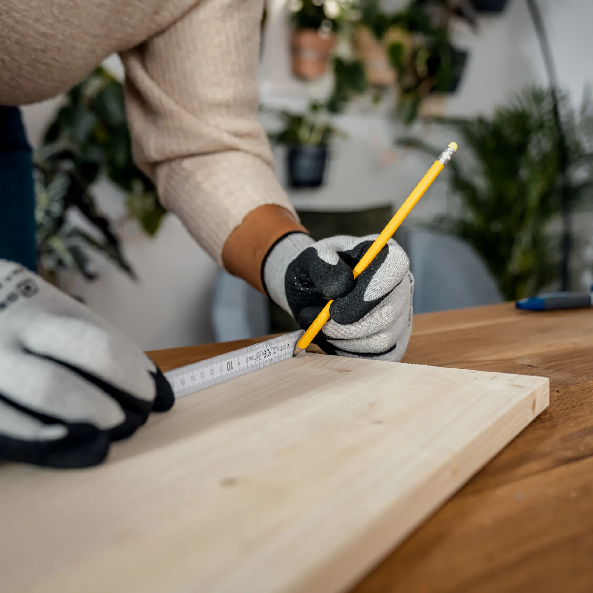 Il pannello in legno viene misurato con un metro pieghevole. Con una matita si marca un segno a 2 cm dal bordo.