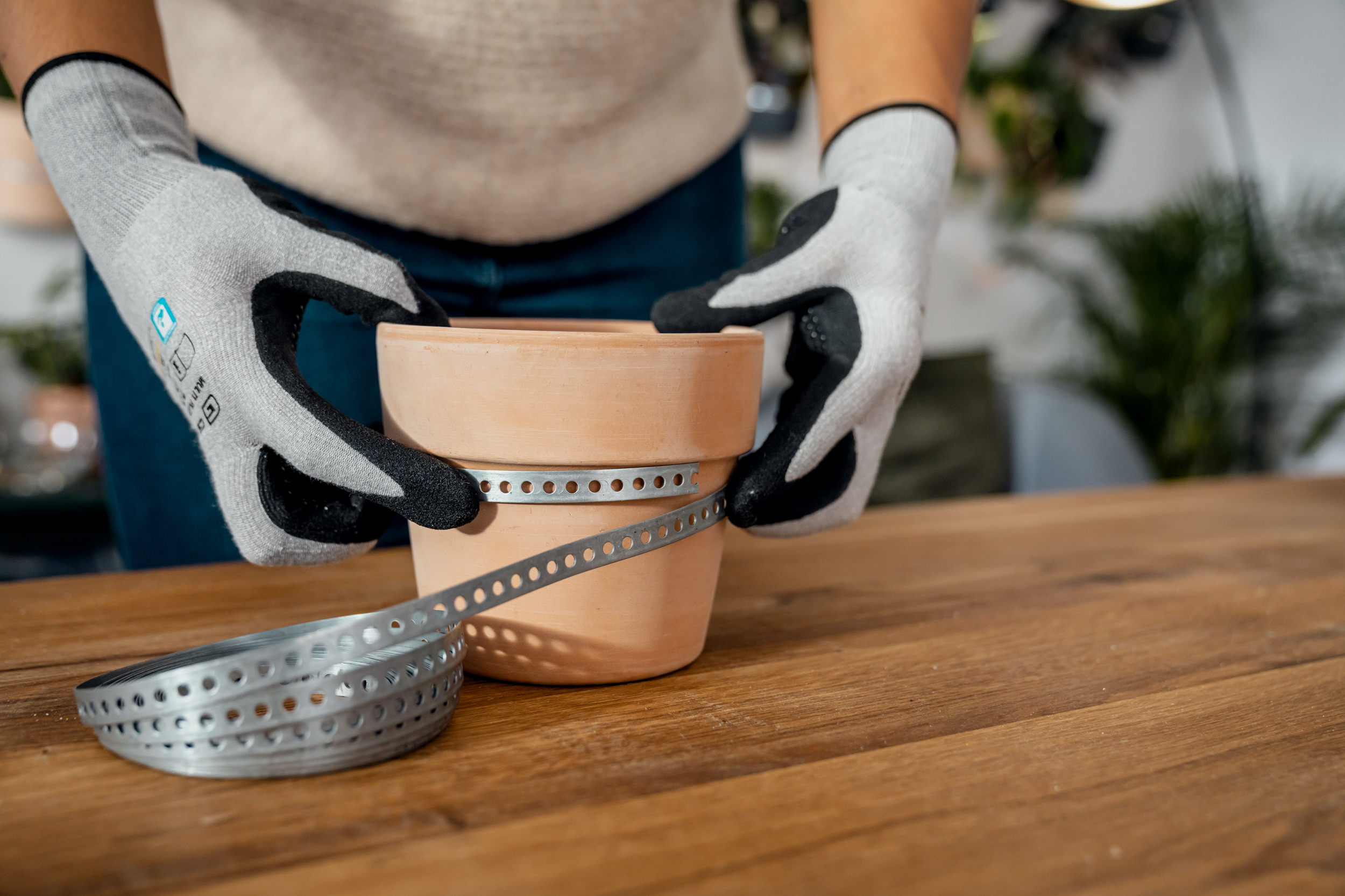 Il nastro perforato viene posizionato intorno a un vaso di terracotta creando una lieve sporgenza.