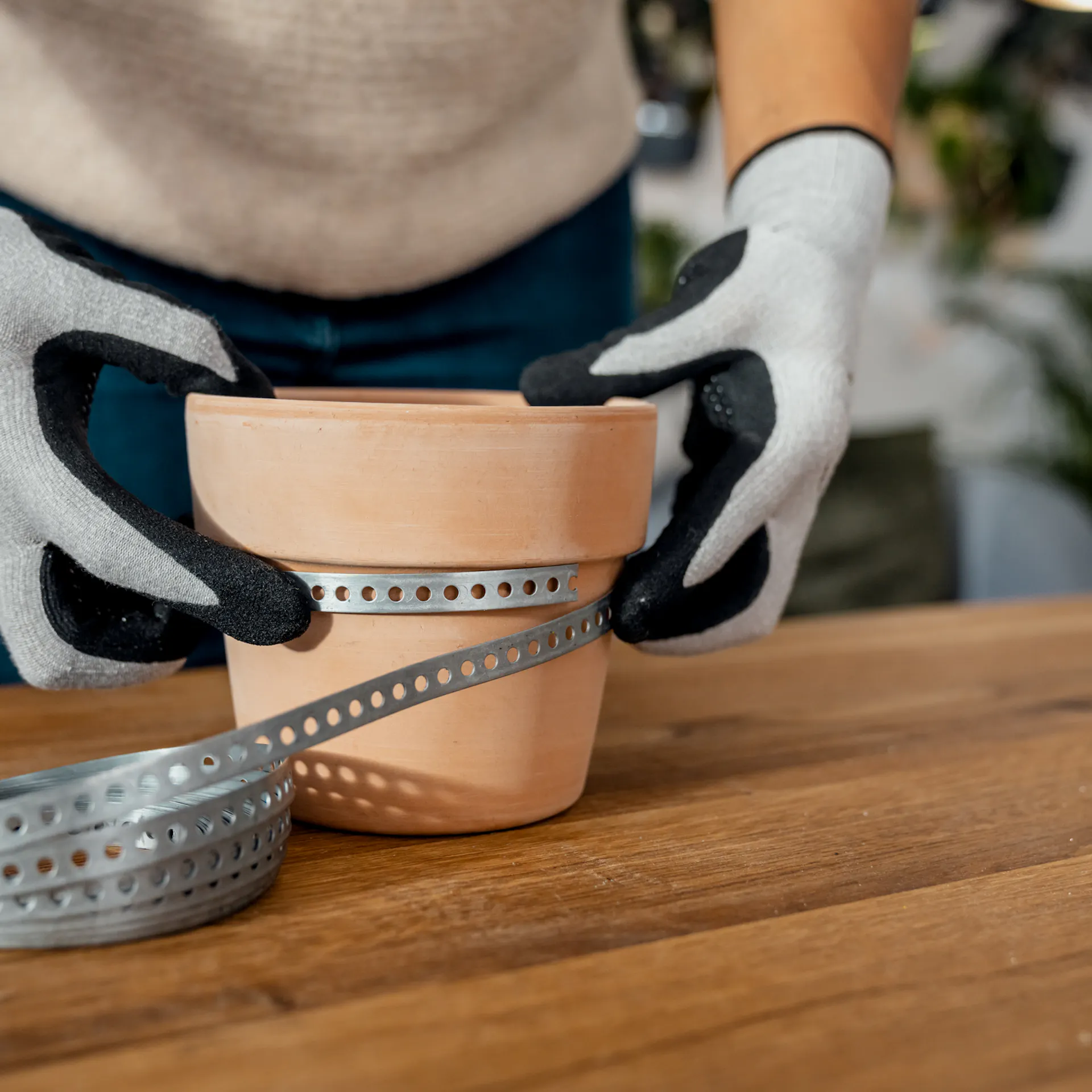 Il nastro perforato viene posizionato intorno a un vaso di terracotta creando una lieve sporgenza.