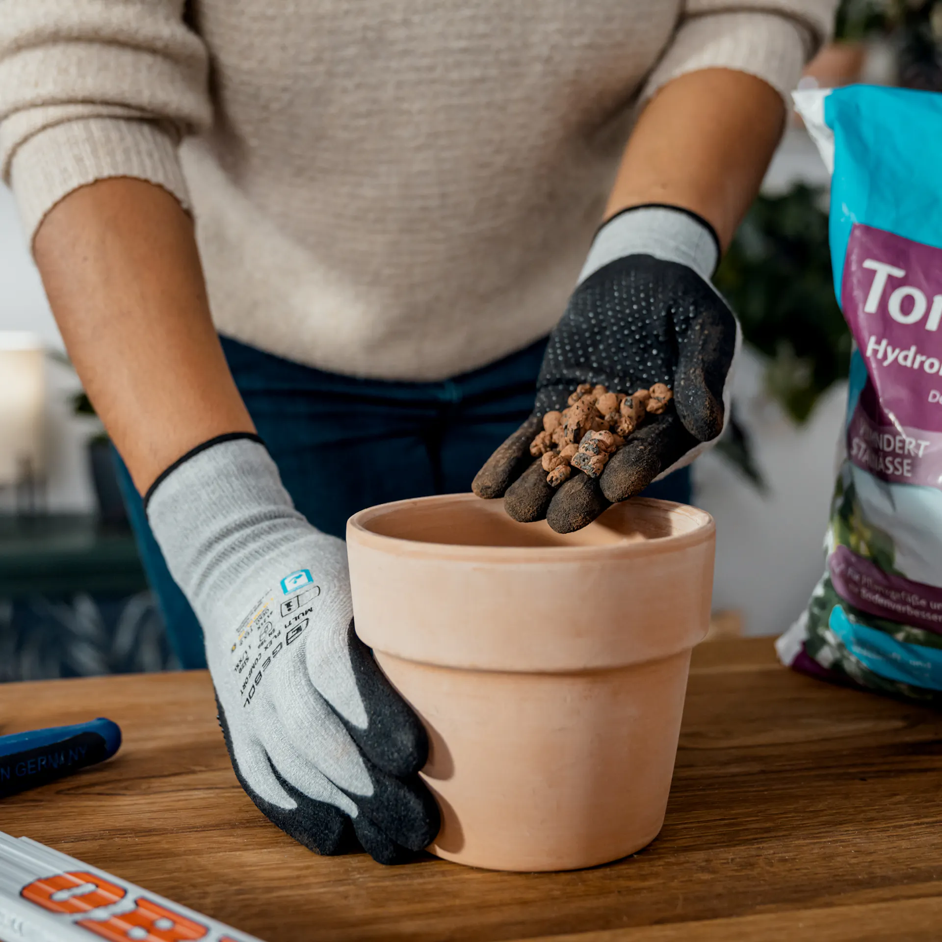 Nel vaso viene versata una manciata di granuli di argilla.