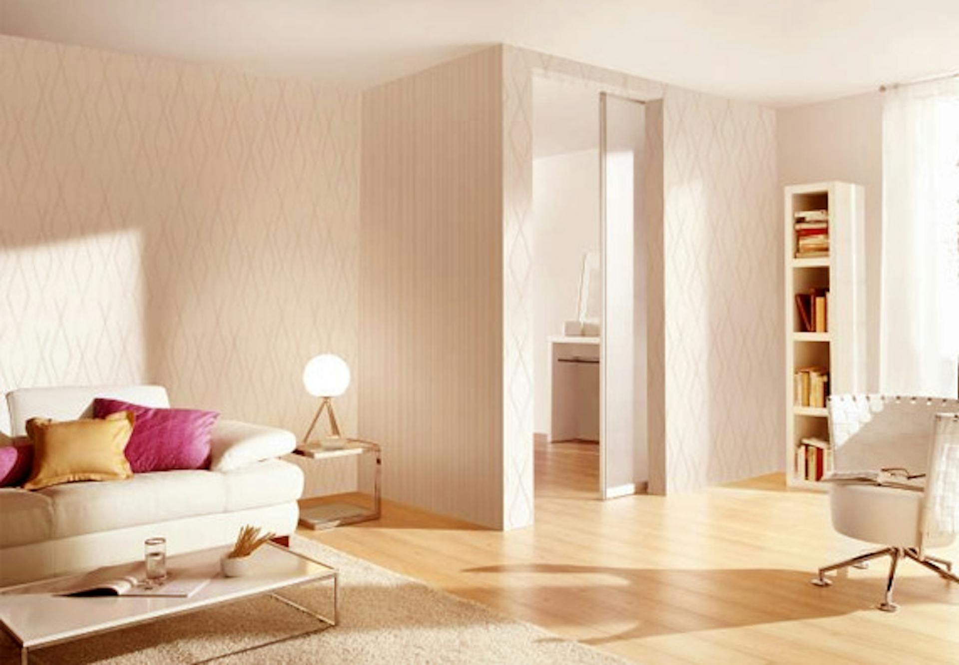 Il salotto in bianco con divano, poltrona e scaffale è illuminato con una luce bianca extra calda.