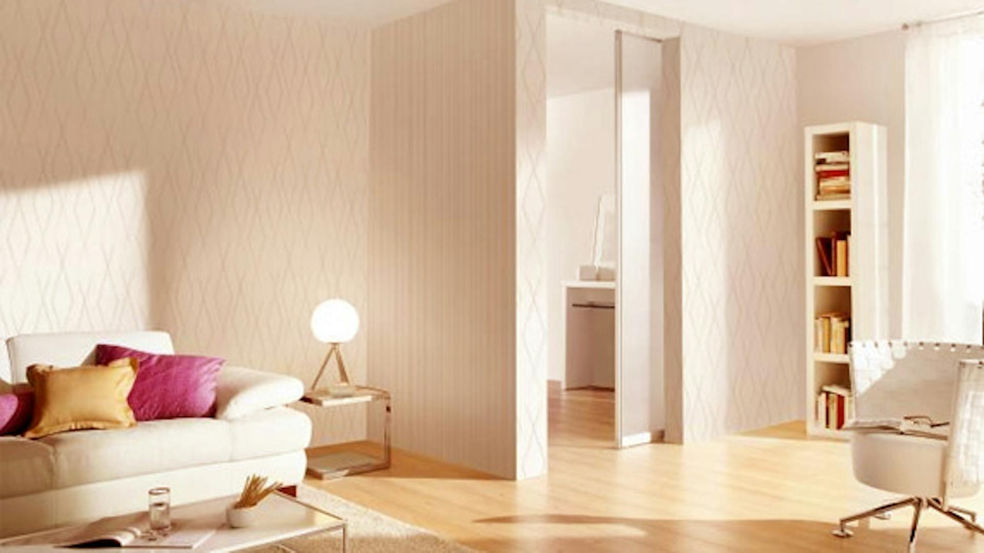 Wohnzimmer in weiß mit Sofa, Sessel und Regal wird mit extra warmweißen Licht beleuchtet.