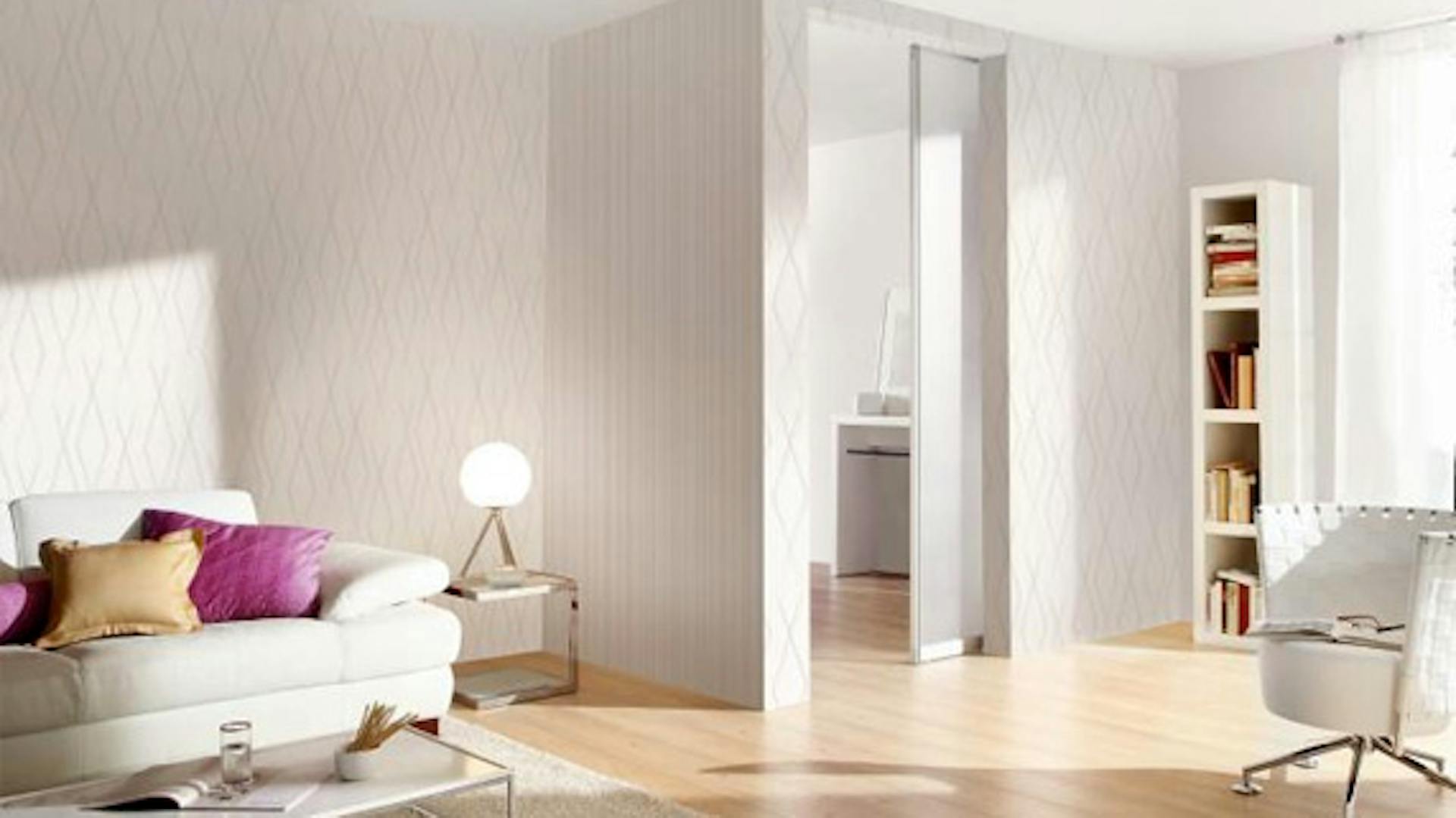 Weißes Wohnzimmer mit Sofa, Sessel und Regal wird mit neutralweißem Licht beleuchtet.