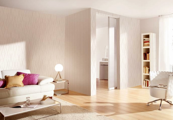 Salotto bianco con divano, poltrona e scaffale illuminato con una luce bianca calda.