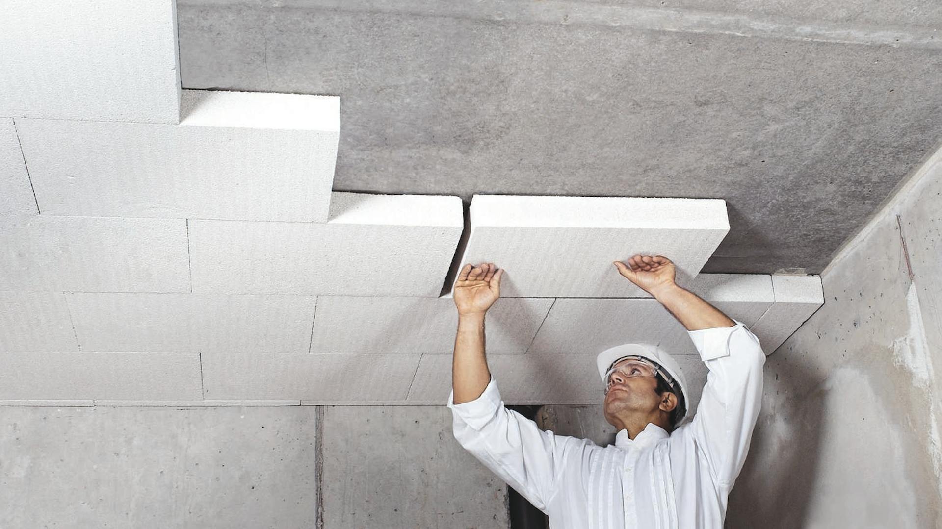 Heimwerker montiert Polystyrol-Platten an der Kellerdecke.
