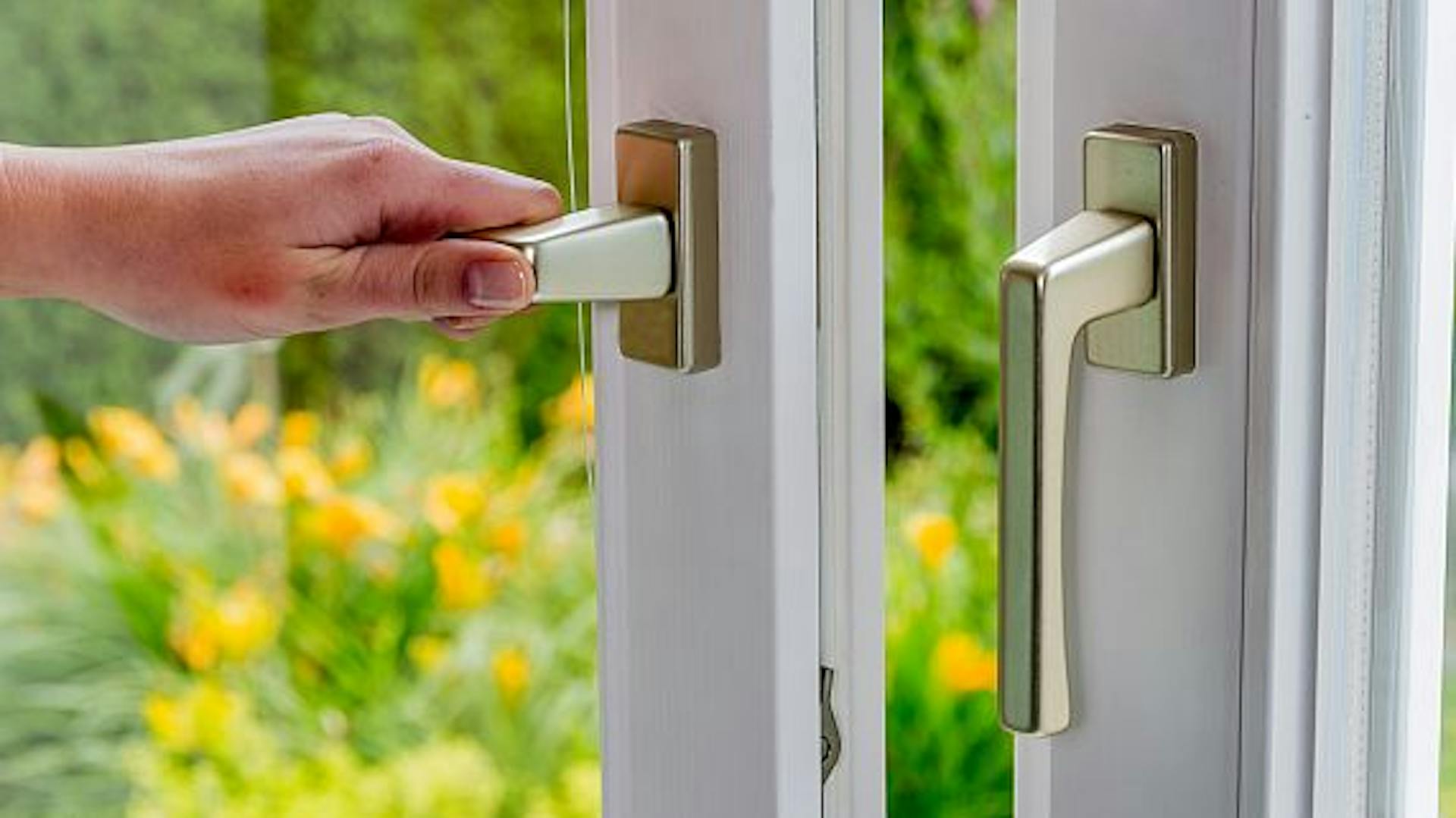 Eine Person öffnet ein Fenster.