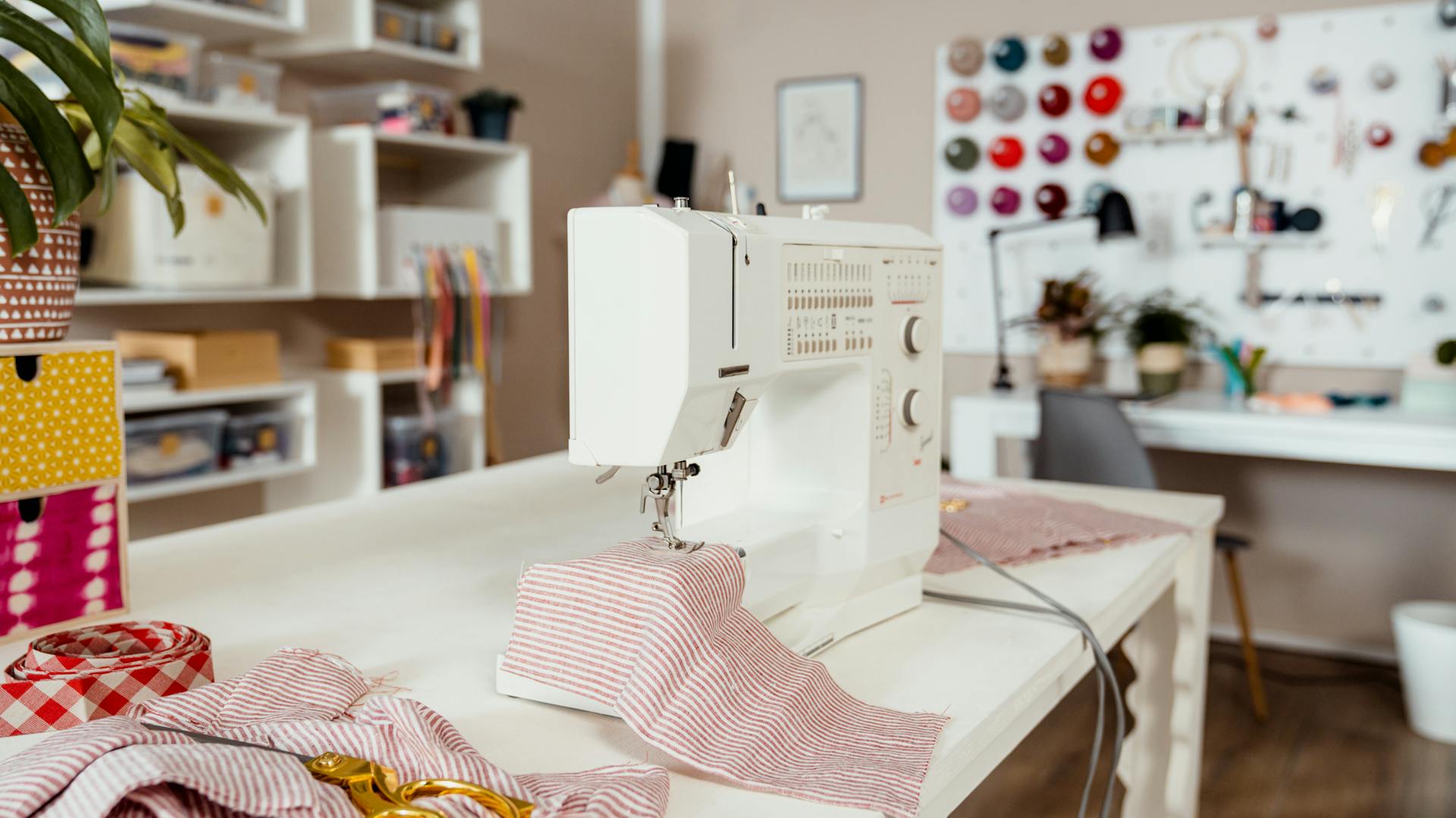 Eine Nähmaschine auf deinem Tisch mit Stoffresten in einem Hobbyraum
