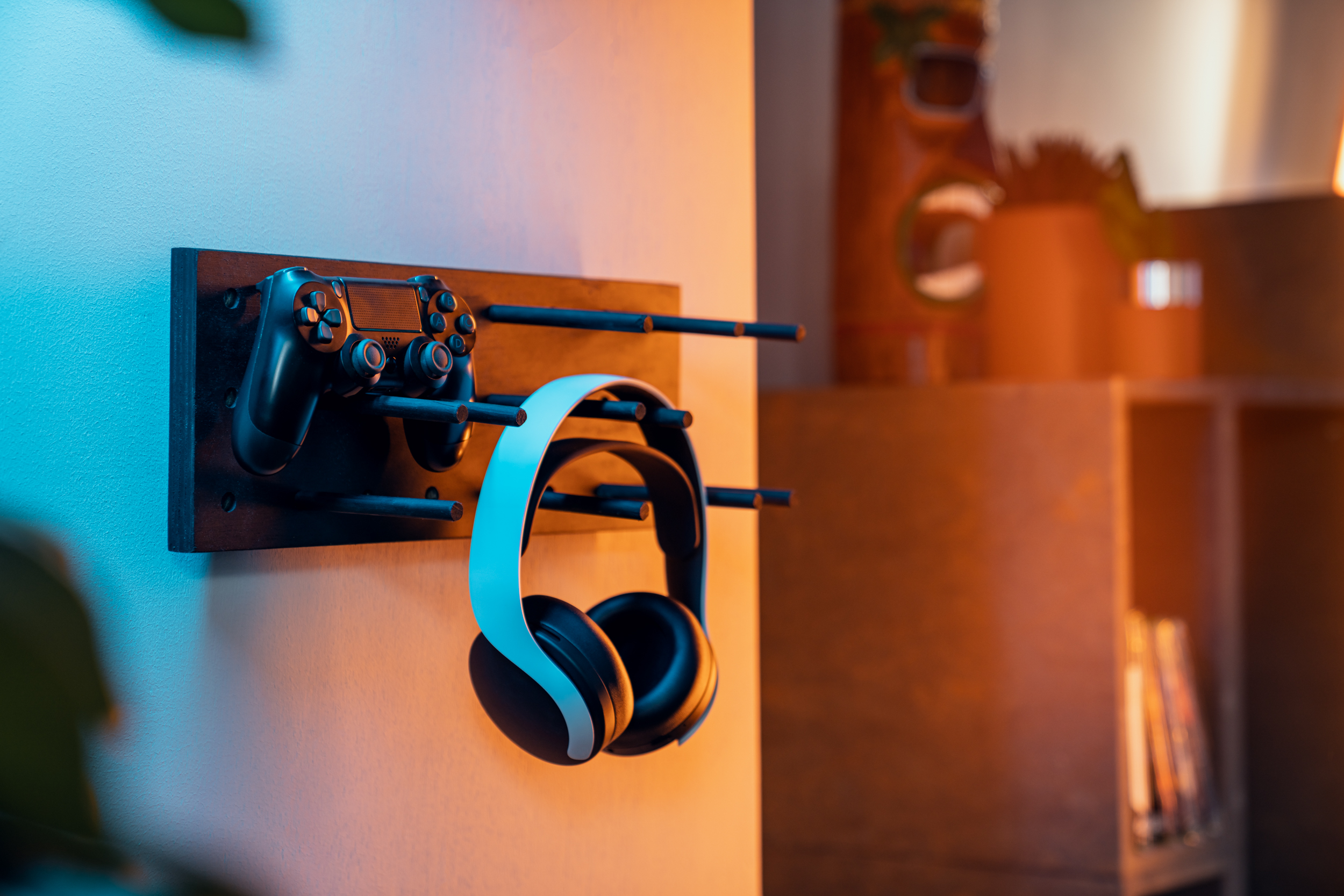 Kopfhörer hängen an einem Pegboard, daneben ein Controller.