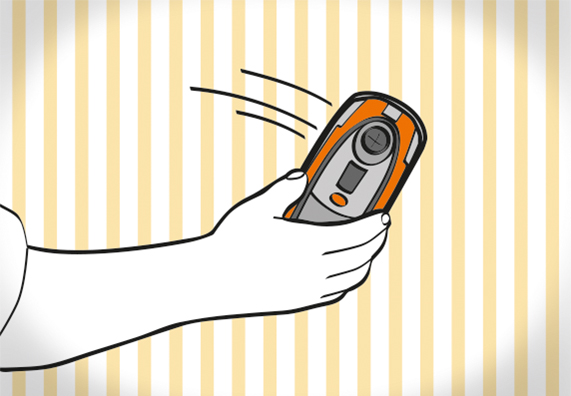 Heimwerker prüft Montagebereich an Wand mit Ortungsgerät