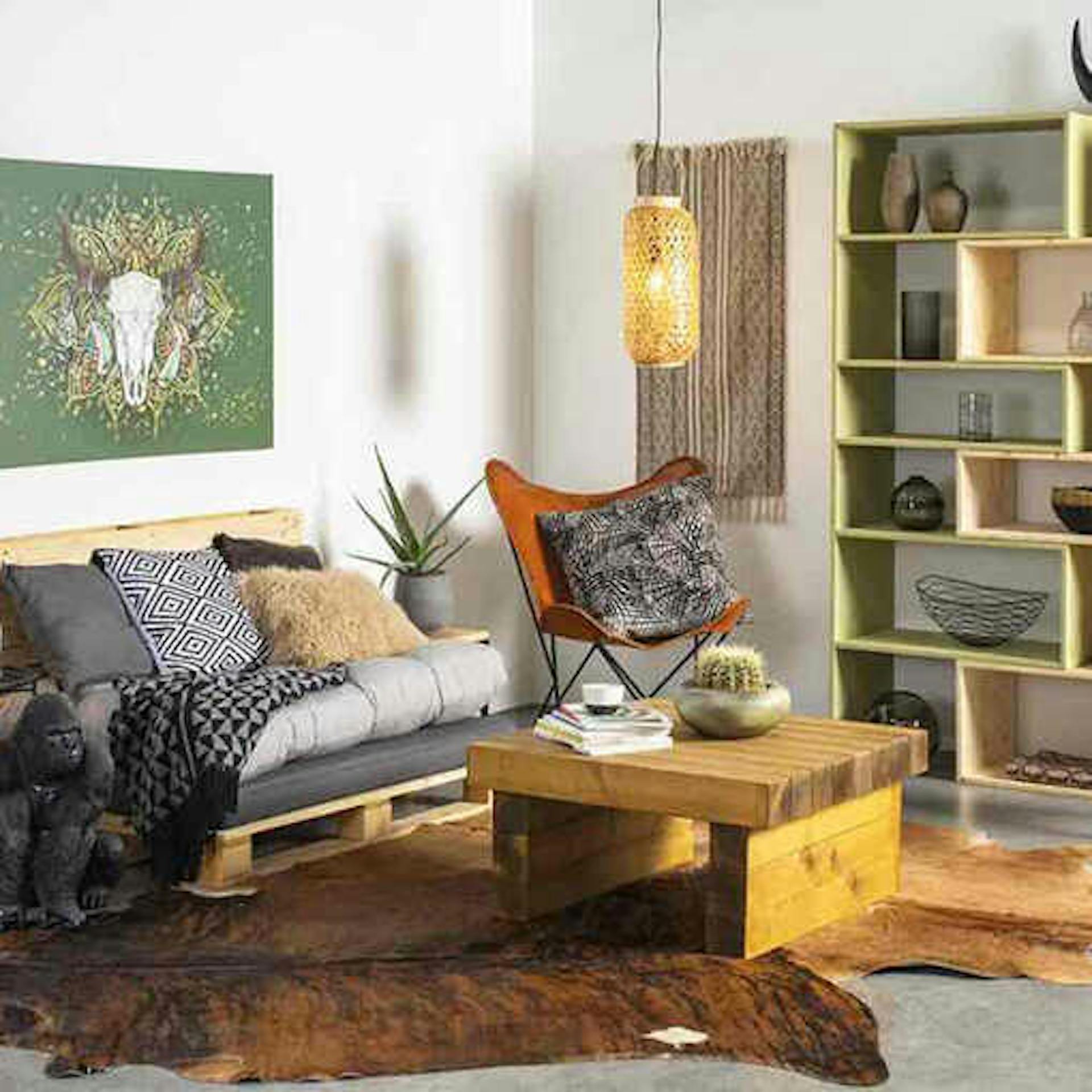 Wohnzimmer mit rustikaler Einrichtung aus Palettensofa, Couchtisch aus Bohlen und Kuhfell als Teppich