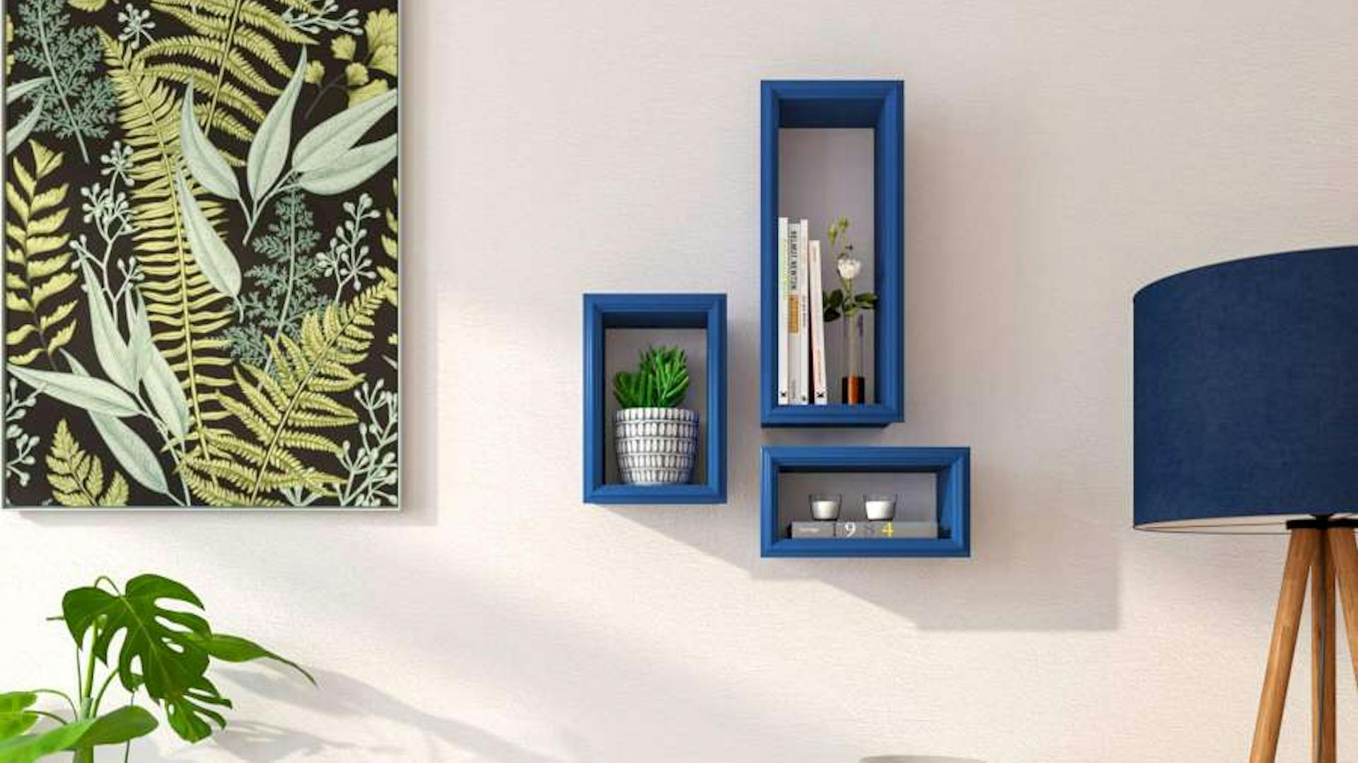 Blaue Rahmenregale an weißer Wand neben grünem Bild, Steh- und Tischlampe und weißem Standregal