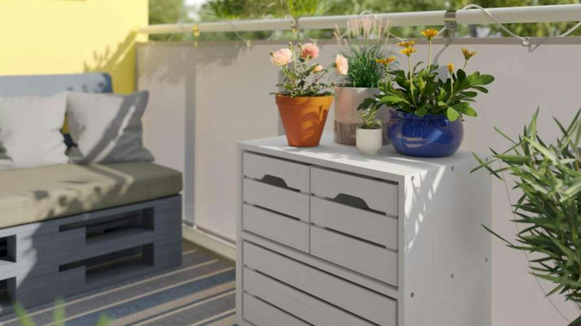 Ein Pflanzenregal mit Stauraum auf einem sonnigen Balkon mit vielen Pflanzen