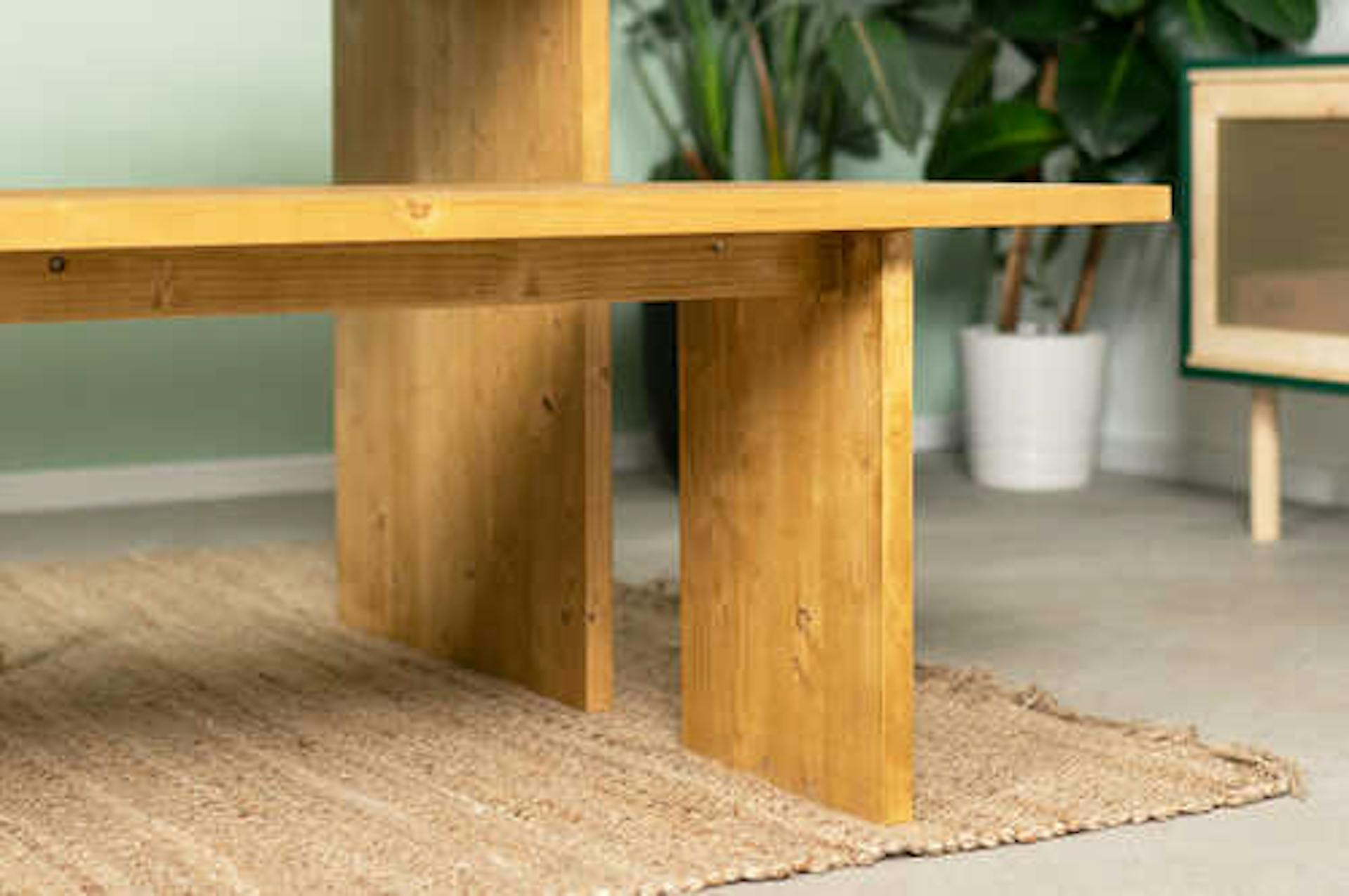 Bank August steht vor Tisch August auf einem beigen Teppich vor einer pastellgrünen Wand,