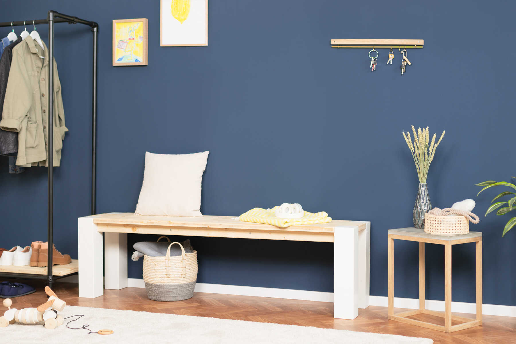 Bank Maren vor einer blauen Wand.