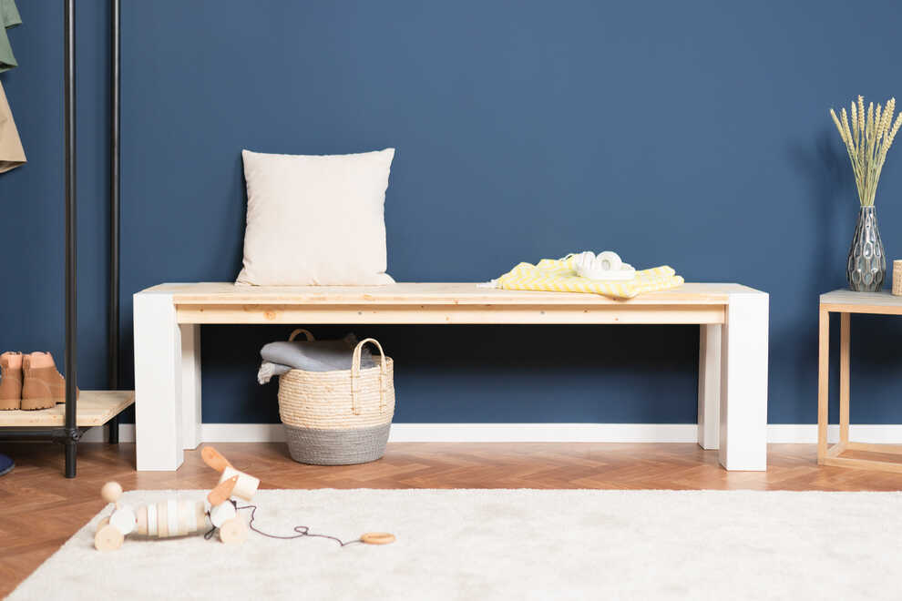 Frontalansicht von Bank Maren vor einer blauen Wand.