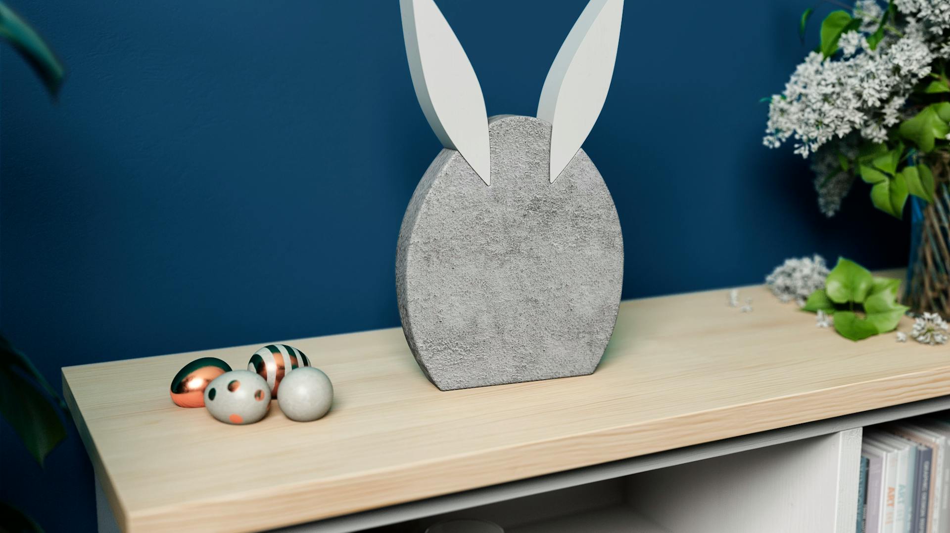 Hase aus Beton steht auf Regal vor dunkelblauer Wand