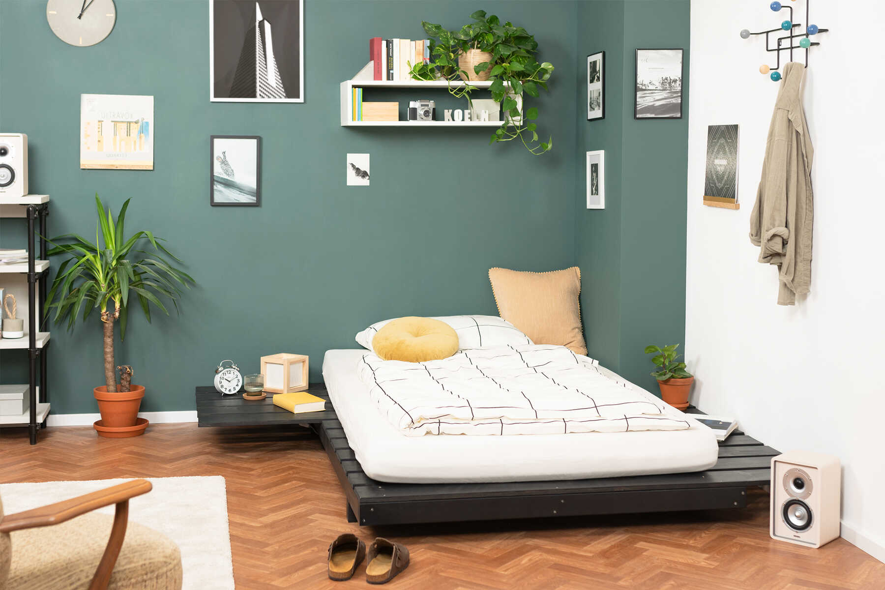 Frontansicht des aus Vollholz bestehenden Bett Ferdinand in schwarz mit integrierten Ablageflächen.