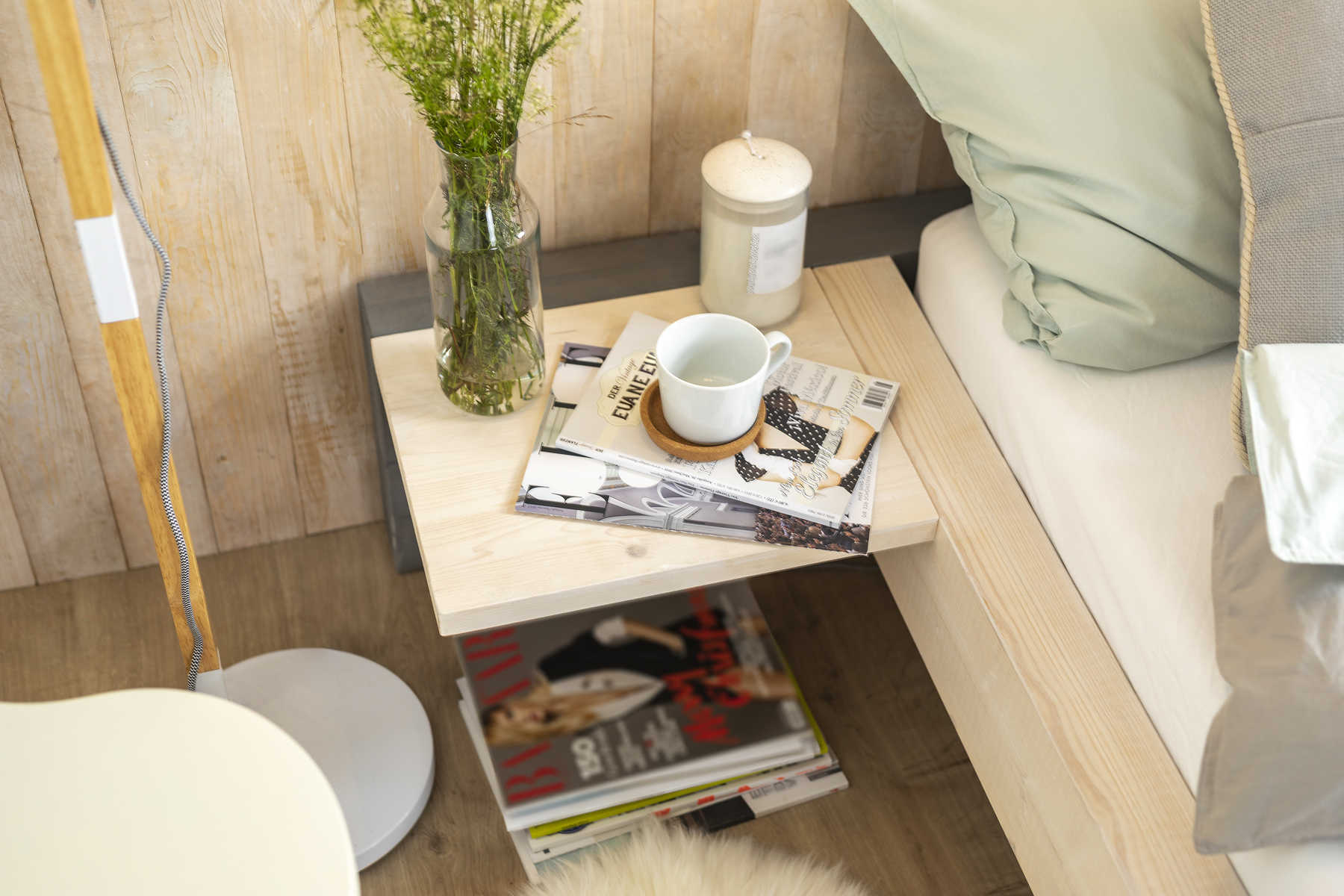 Seitliche Detailansicht des aus Vollholz bestehend Bett Franz mit Nachttisch.