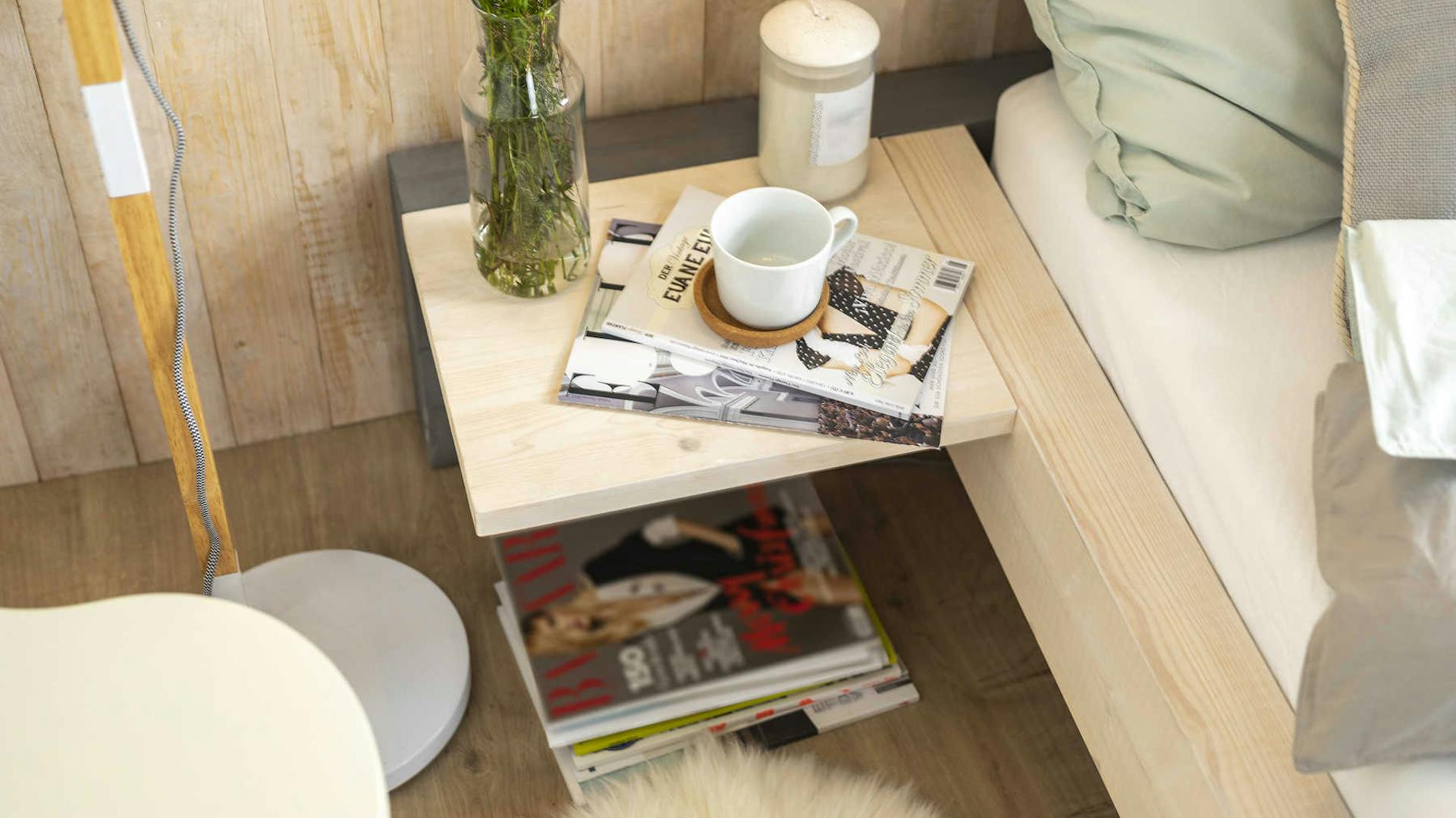 Seitliche Detailansicht des aus Vollholz bestehend Bett Franz mit Nachttisch.