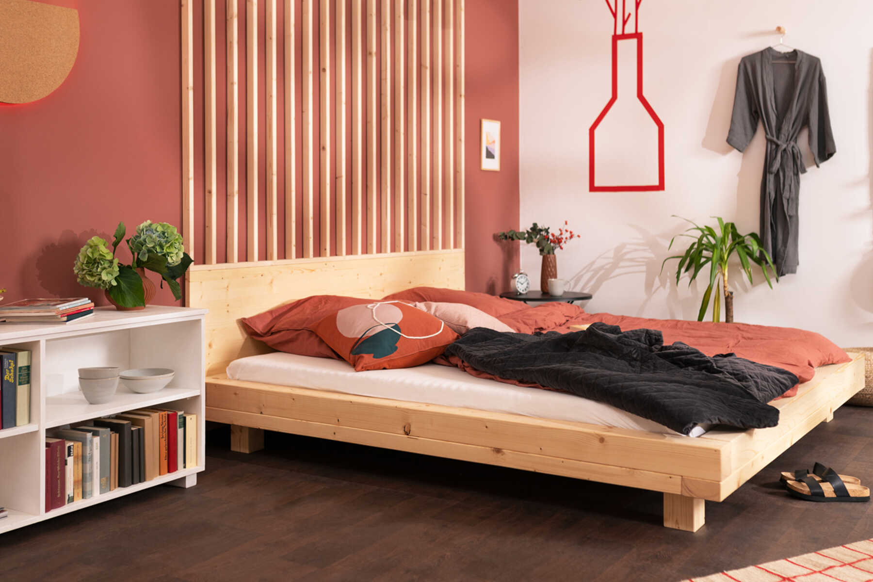 : Seitliche Ansicht des aus Vollholz bestehenden Bett Ludwig in Naturfarbe mit Kopfteil.