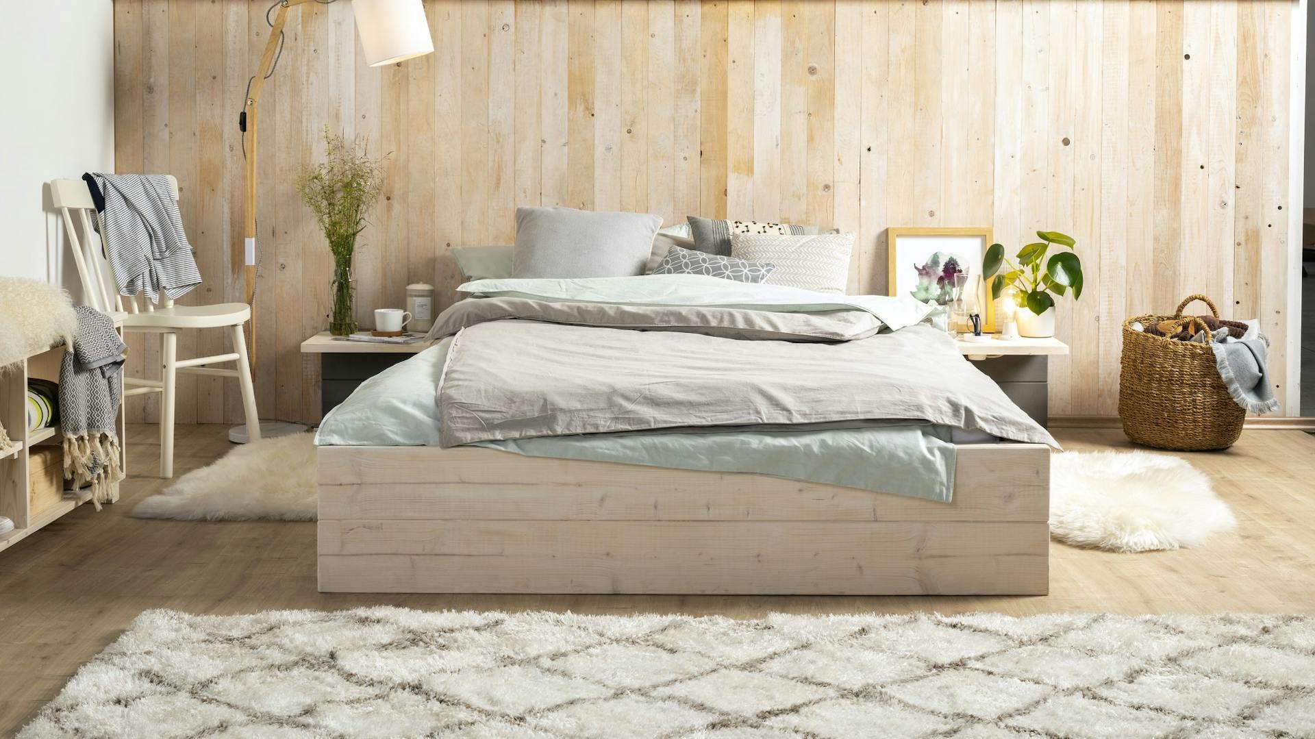 Selbstgebautes Bett aus hellem Holz in Schlafzimmer