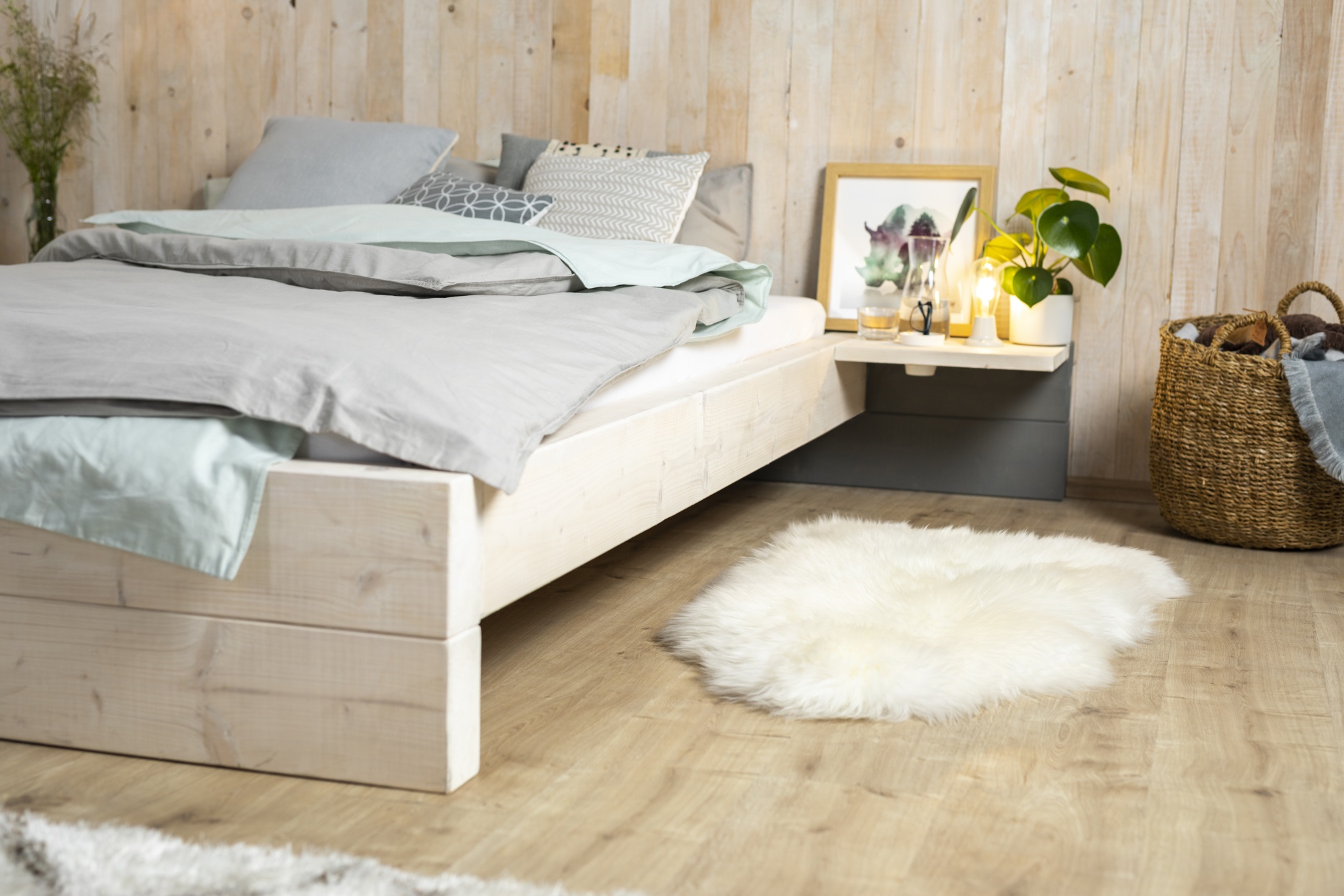 Selbstgebautes Bett mit Nachttisch.