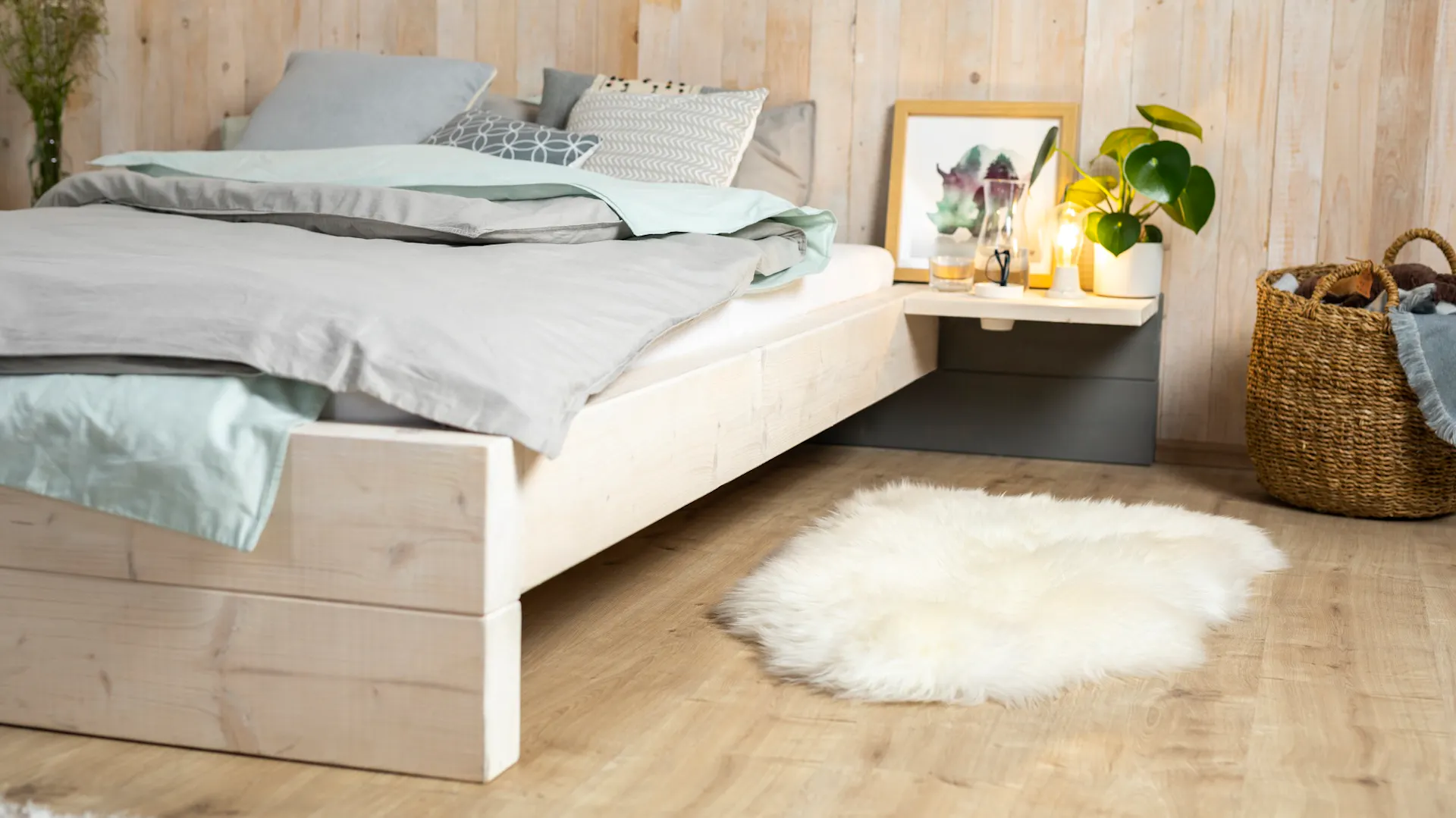 Selbstgebautes Bett mit Nachttisch.
