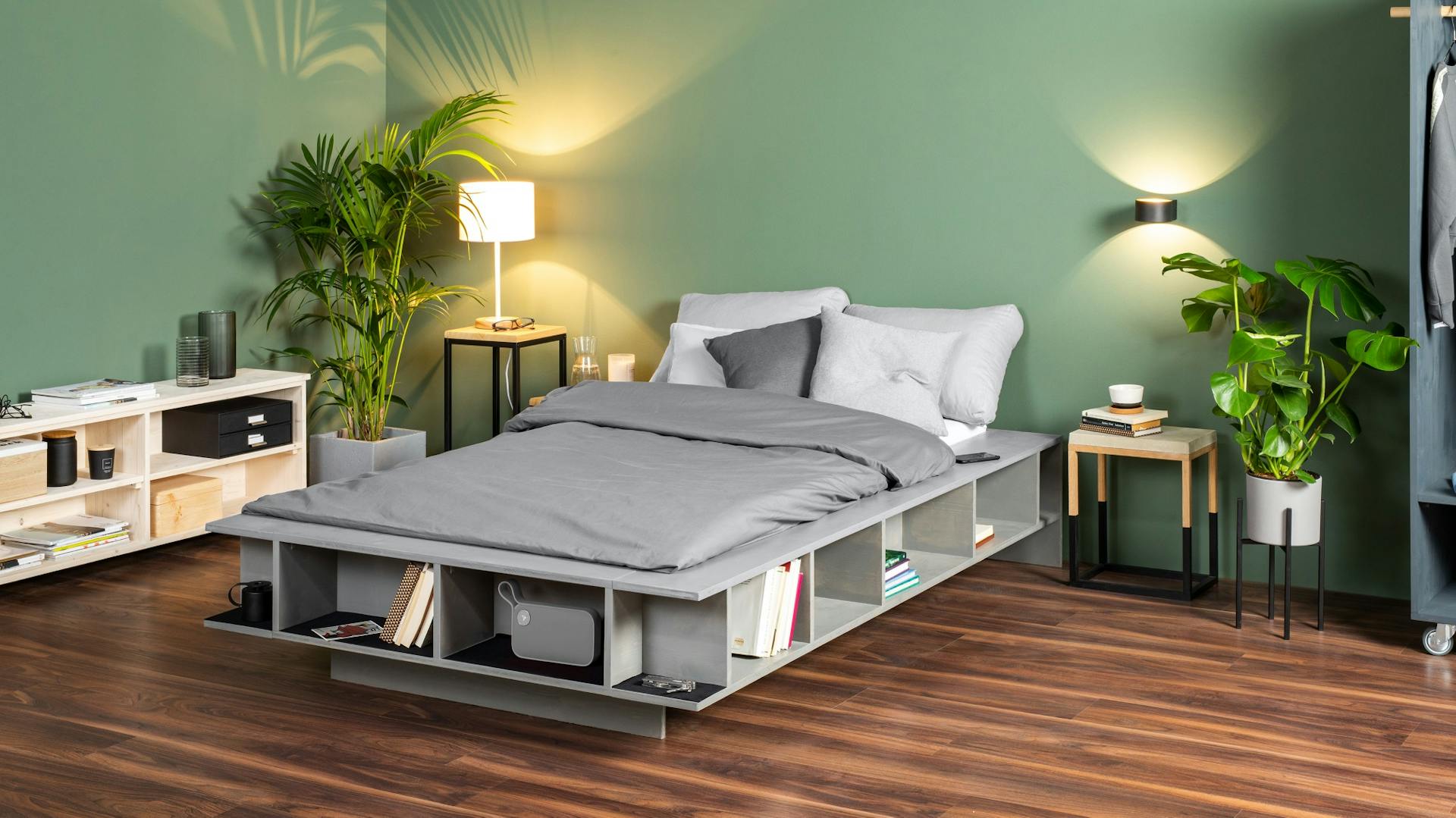 Vlastnoručne postavená posteľ obsahujúca regál na knihy v štýlovej zelenej izbe.