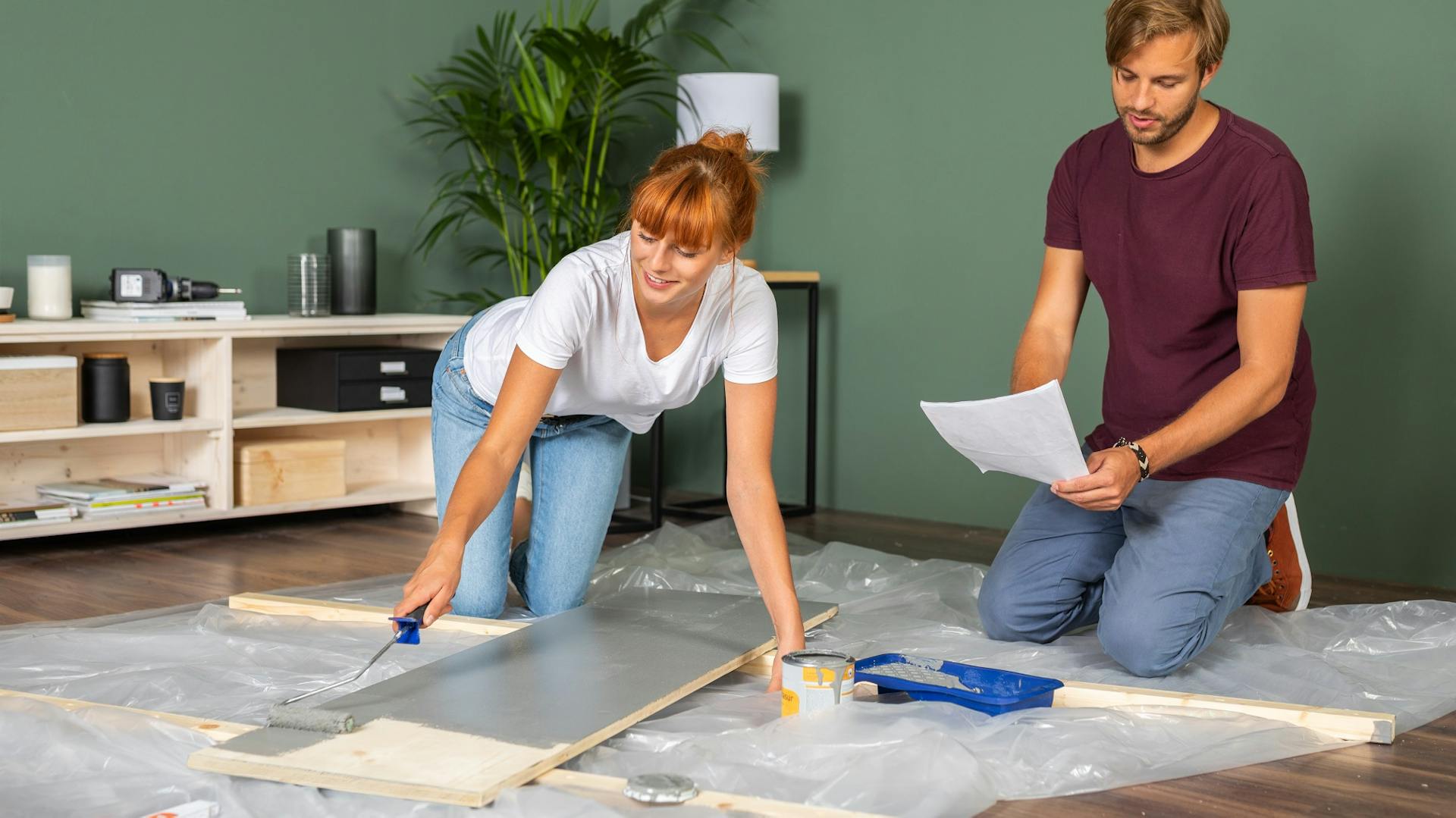 Egy pár szürke festékkel festi az ágy egyik elemét