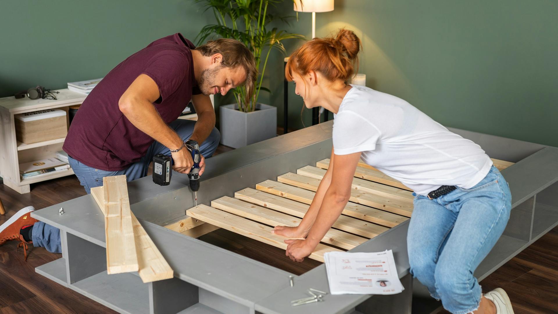 Egy pár az ágyrácsot a saját készítésű ágykeretre csavarozza