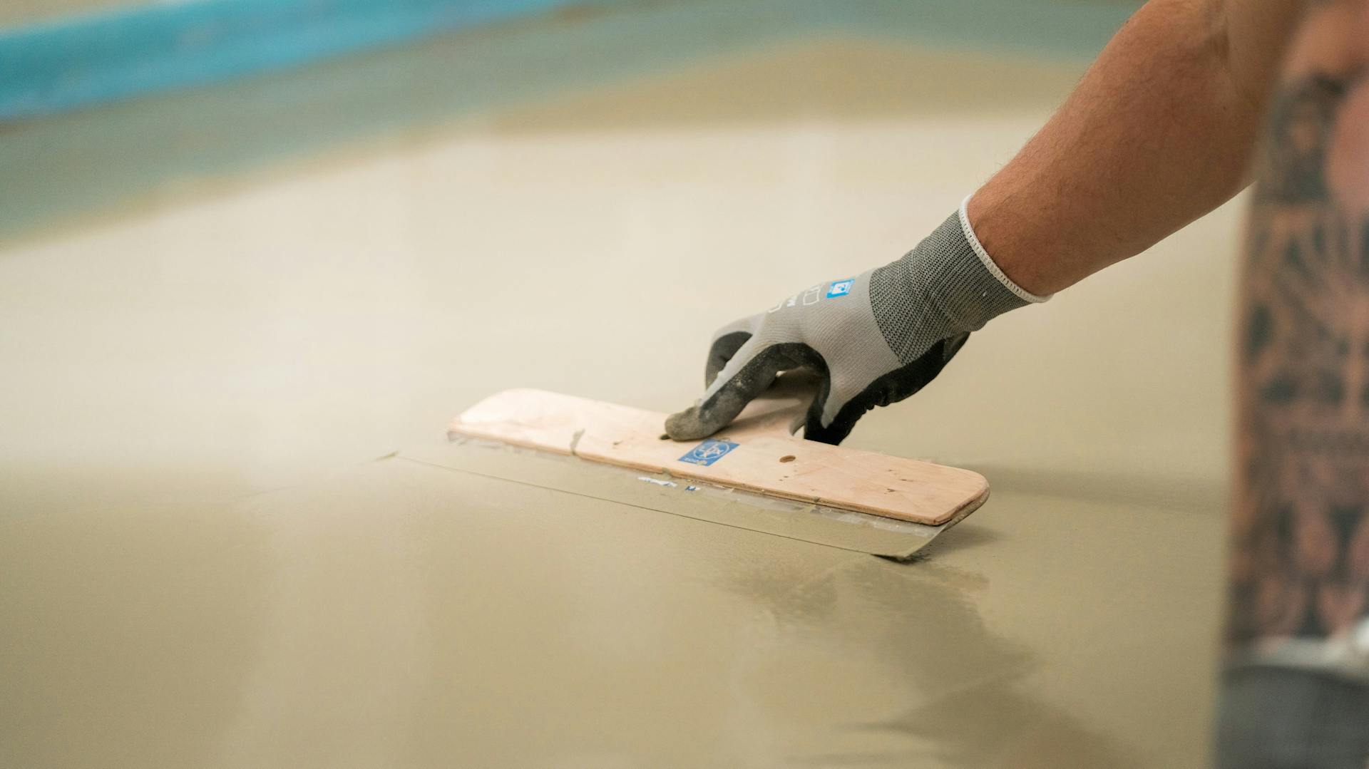 Heimwerker glättet Nivelliermasse.