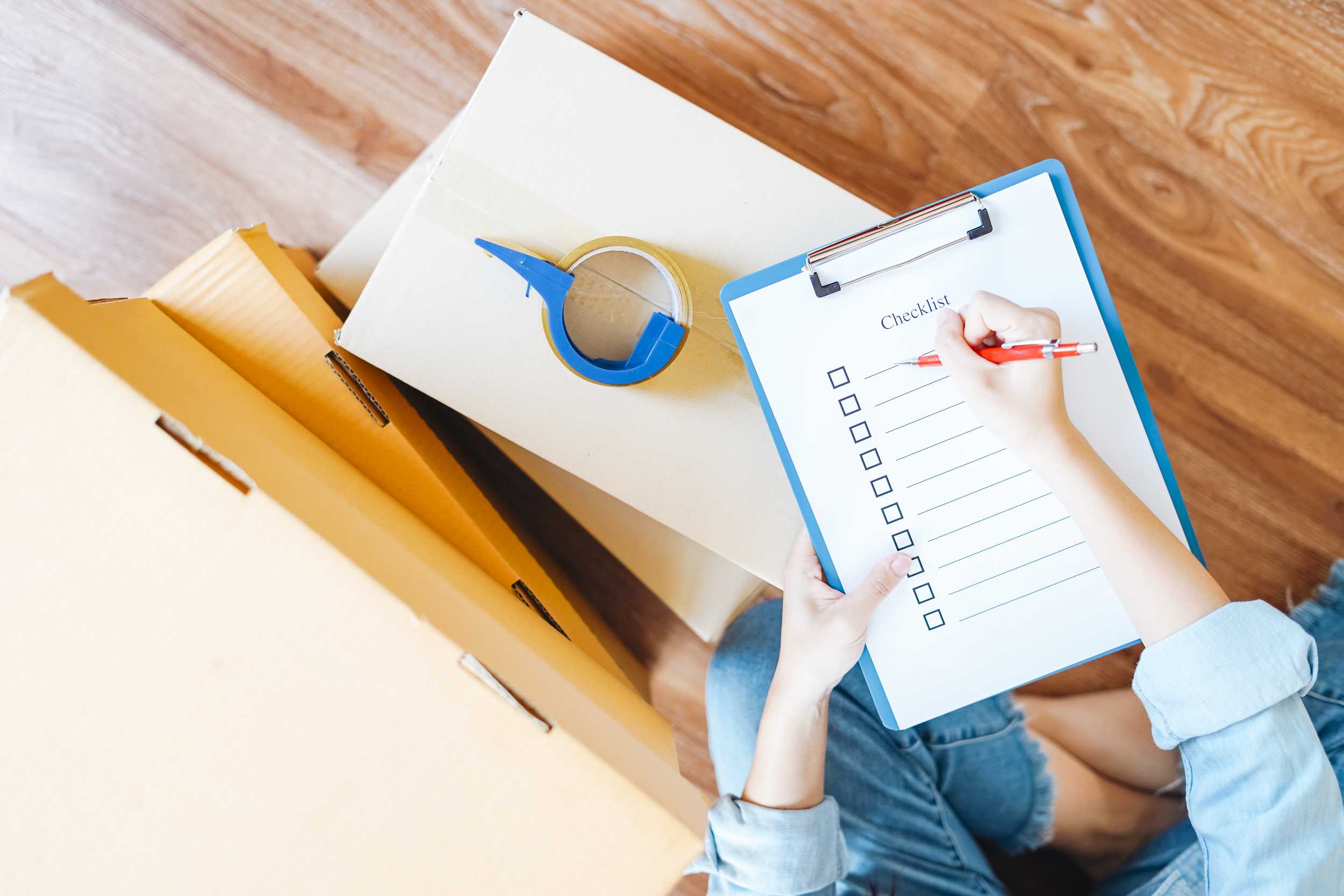 Frau schreibt auf ein Klemmbrett mit Checkliste.