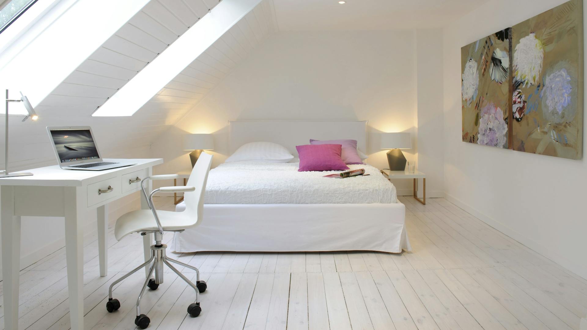 Helles Schlafzimmer mit Dachschräge, Fenster, Schreibtisch und Bett