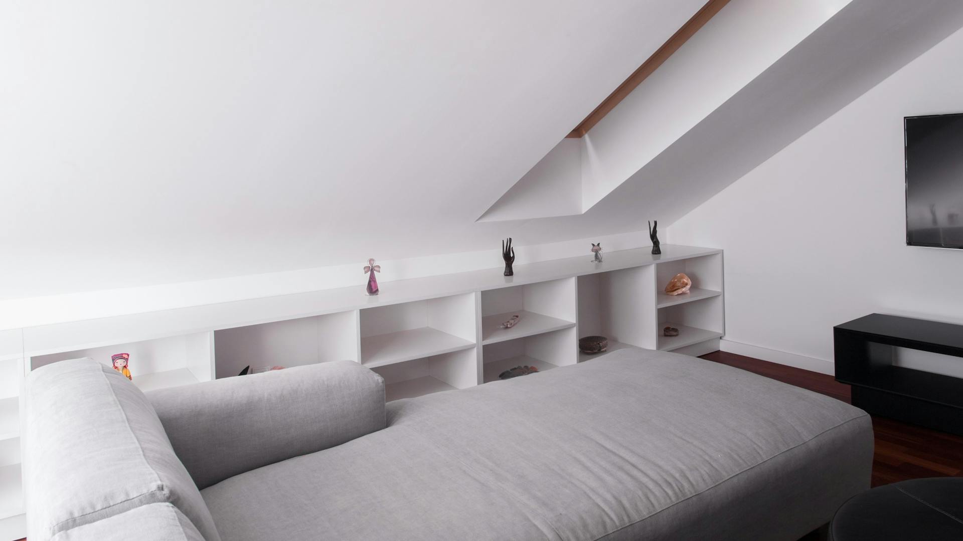 Fehér polc a ferde tető alatt a nappaliban