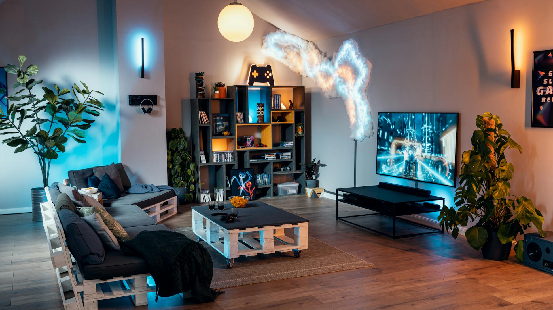 Ein fertig eingerichtetes Gamingzimmer mit Couch, Konsole, TV und passender Beleuchtung