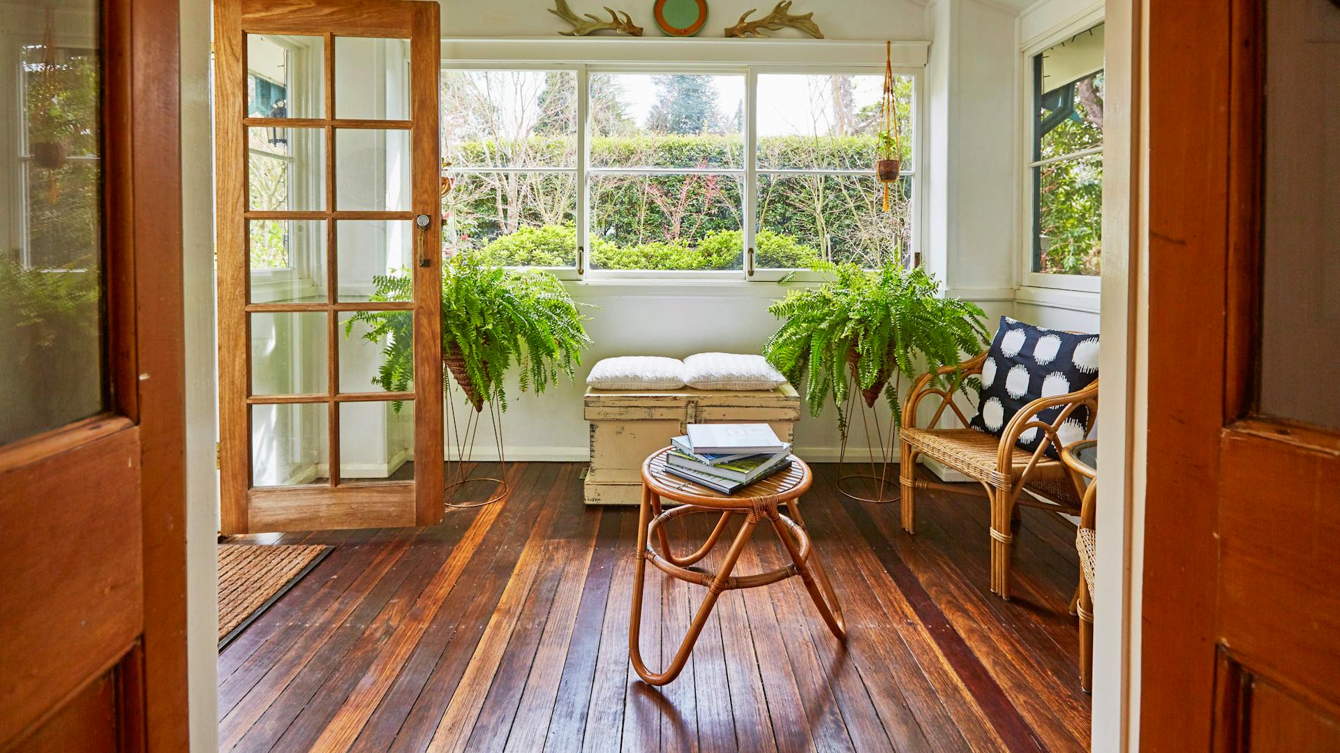 Una stanza luminosa con pavimento a listoni scuro