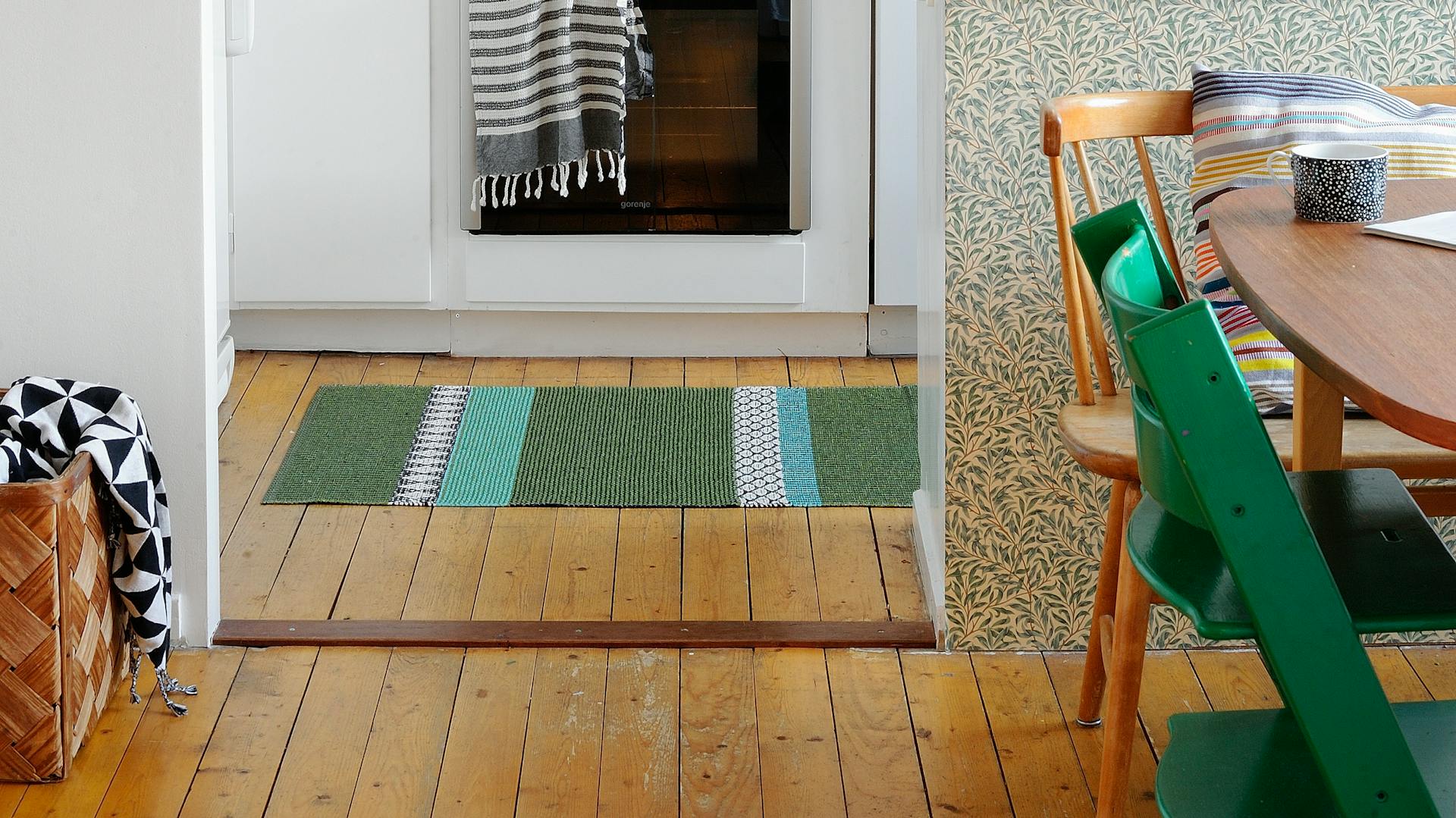 Ein weißer Wohn- und Essbereich mit Dielenboden.