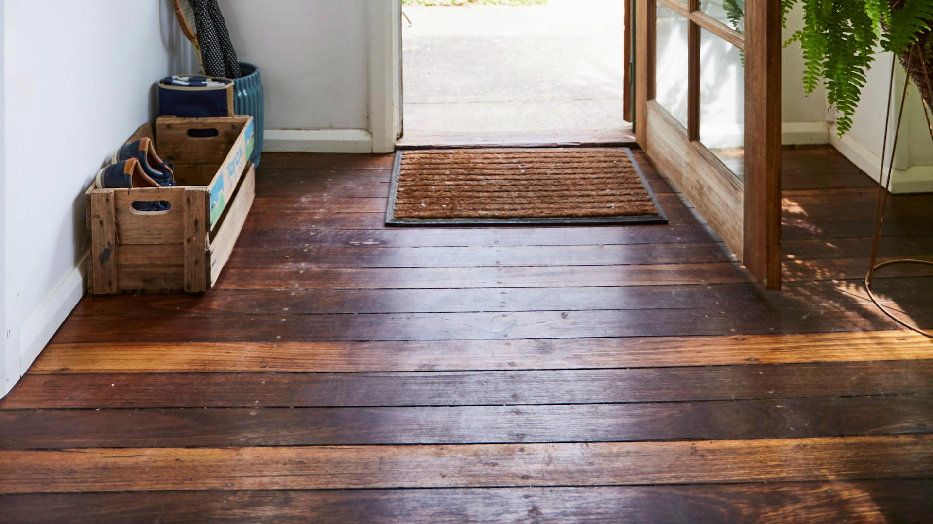 Dunkler, lackierter Dielenboden im Eingangsbereich.